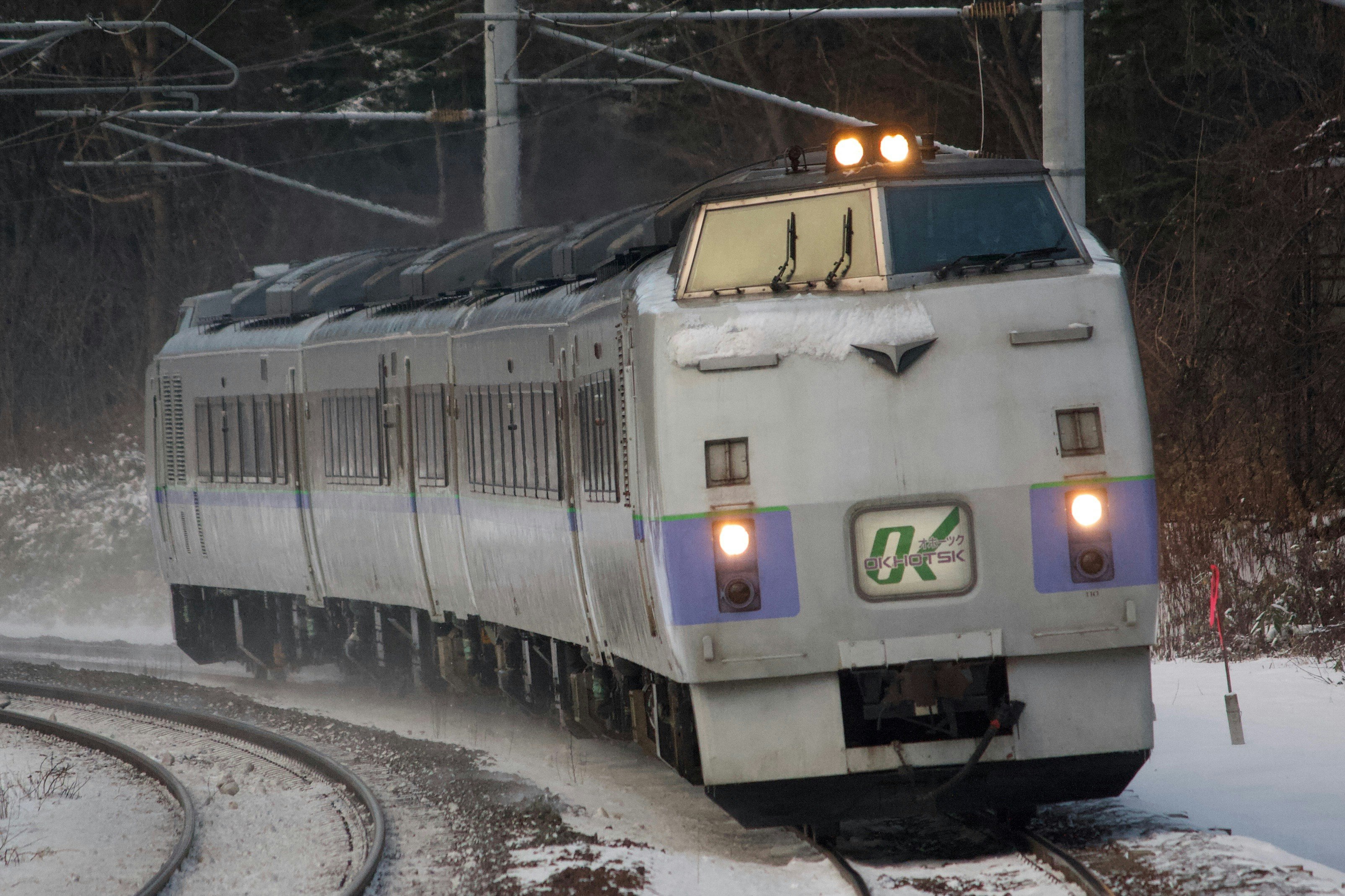 雪の線路を走る電車の正面画像