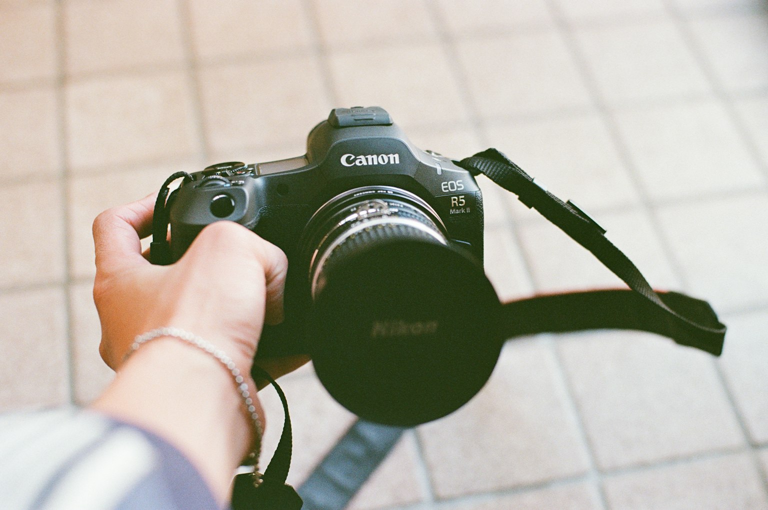 手に持たれたCanonのカメラとレンズが見える写真