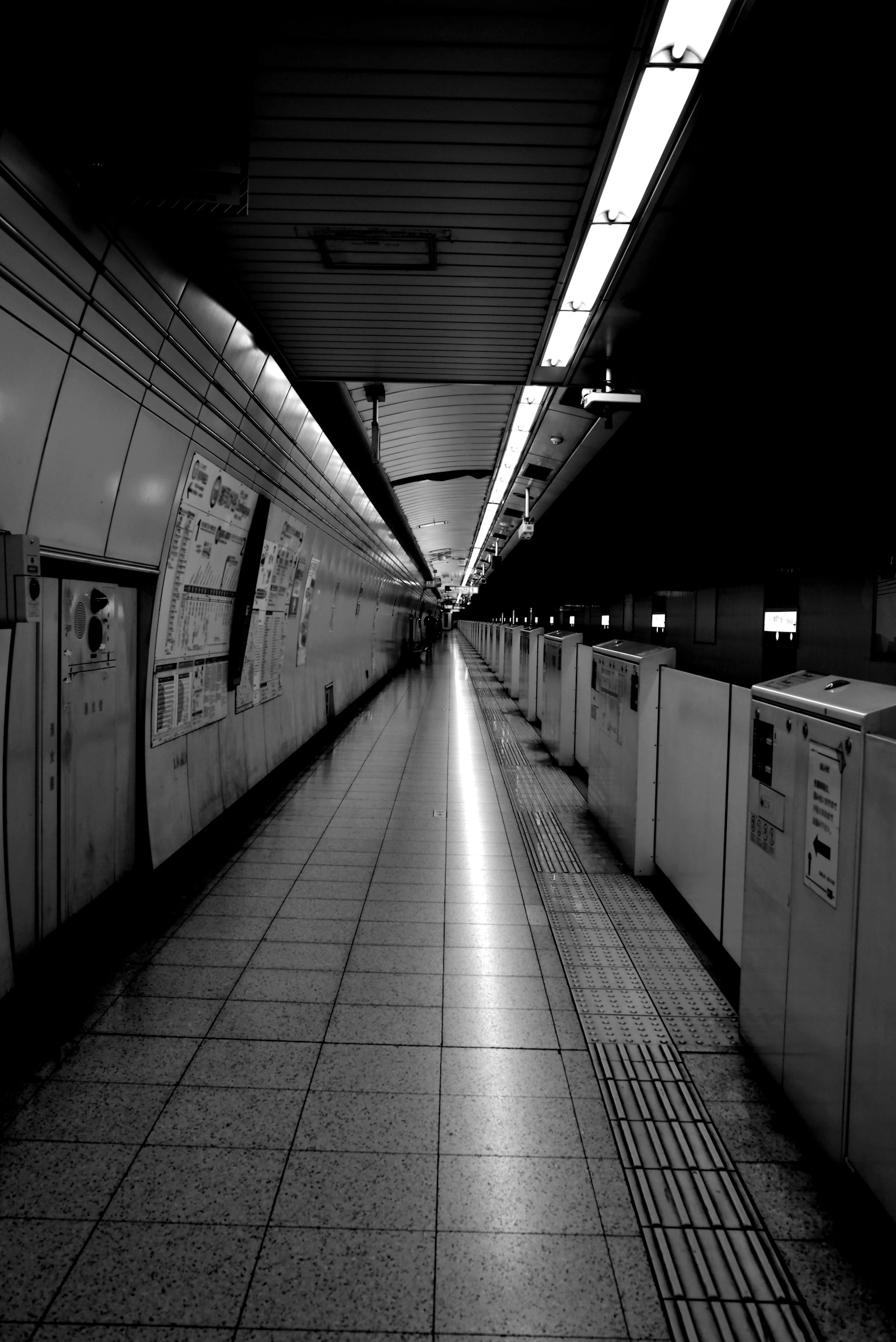 Langer Flur einer dunklen U-Bahn-Station mit schwachem Licht