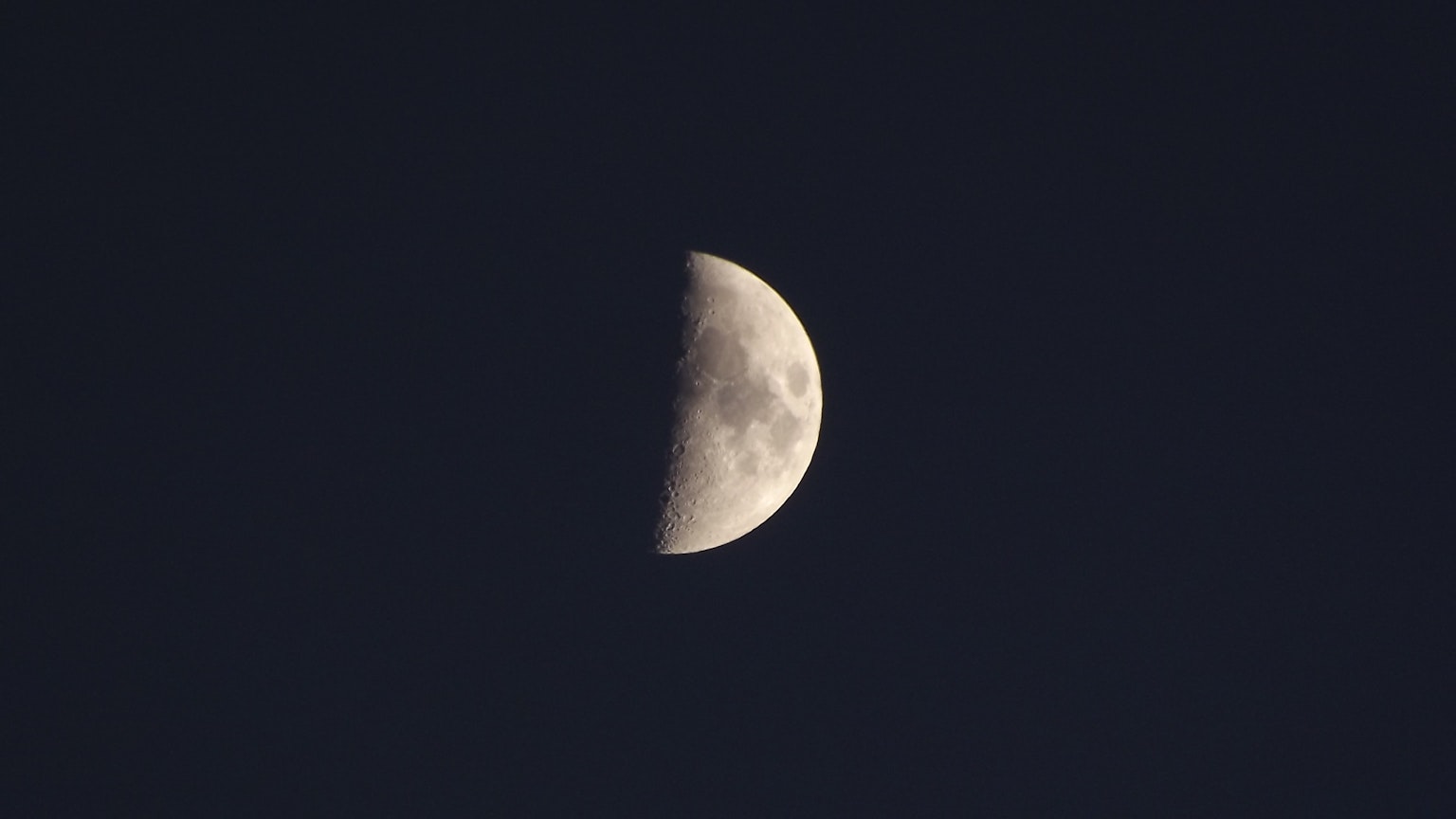 Bulan setengah terlihat di langit gelap