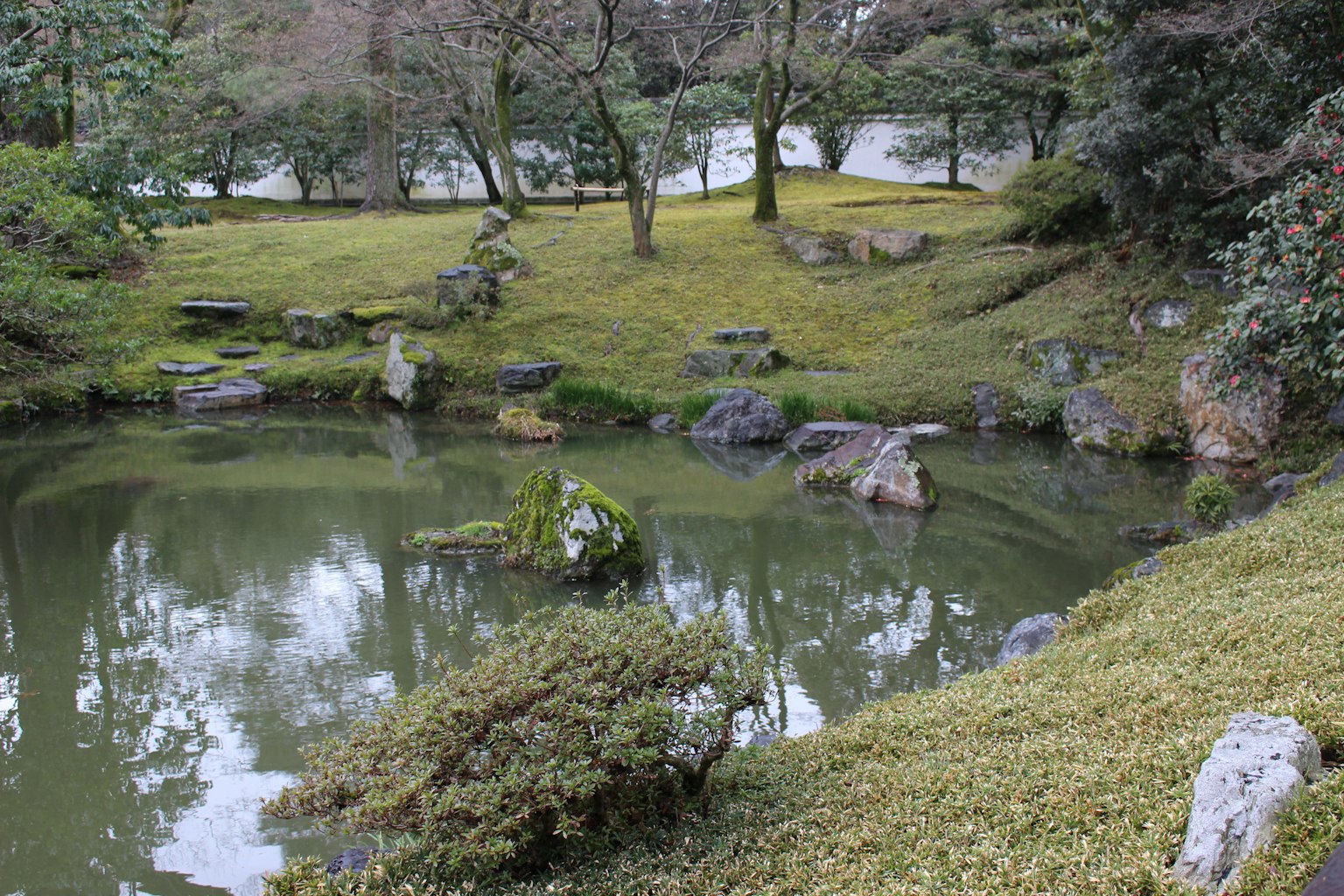 Serene view of a Japanese garden featuring a pond and lush greenery