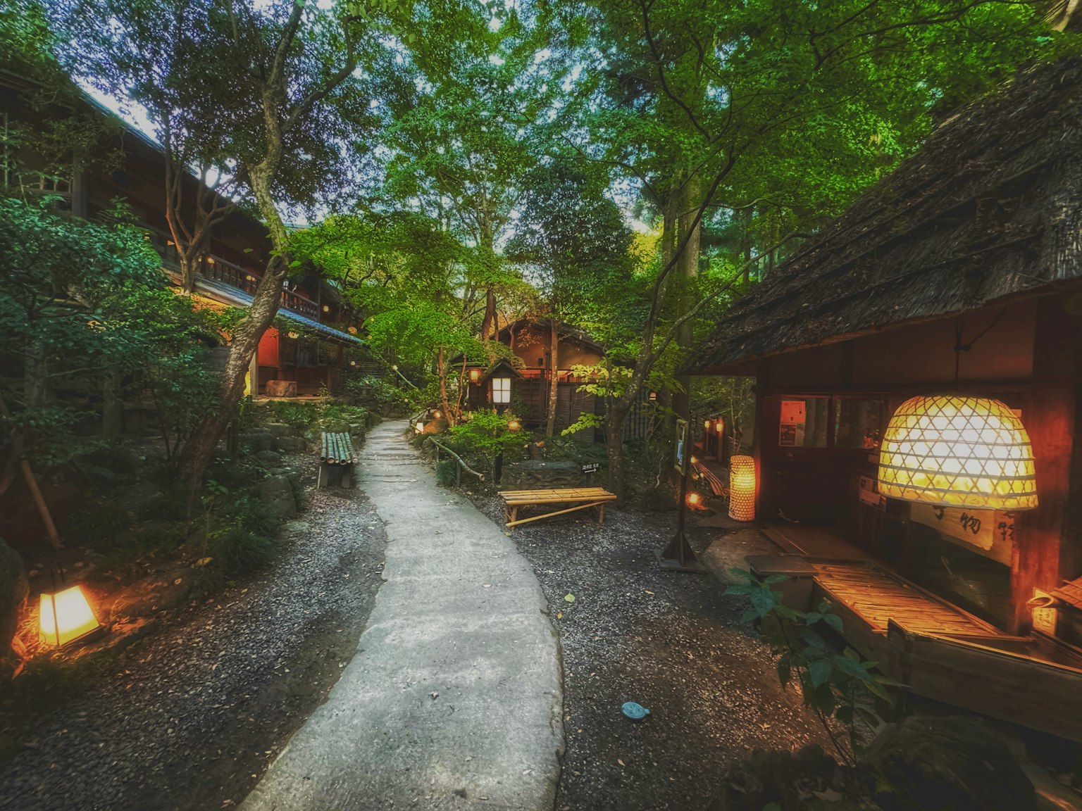 Pathway through a serene garden with traditional Japanese houses