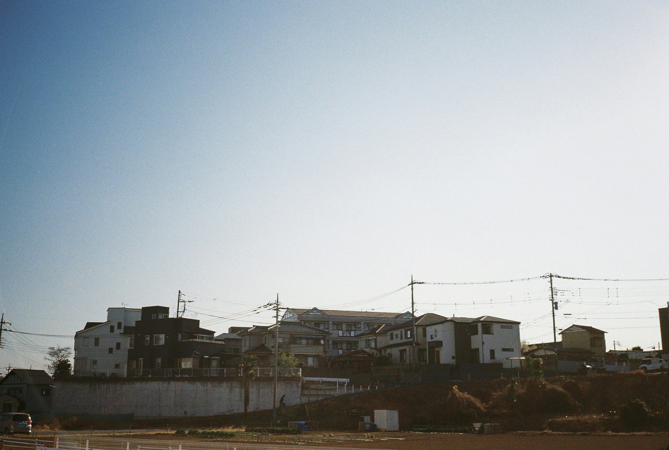 青空の下にある住宅街の風景と電線