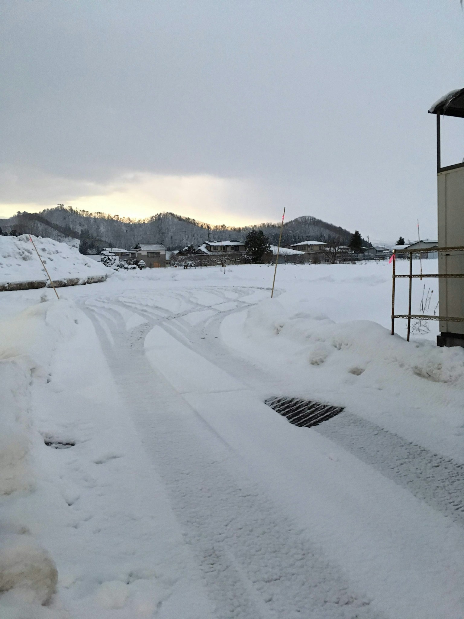 Strada coperta di neve con montagne in lontananza