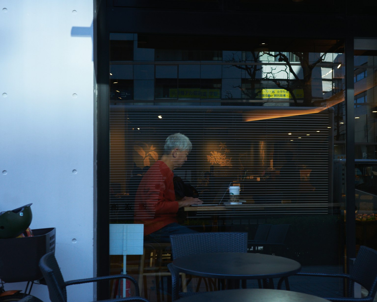 Un uomo con i capelli grigi che lavora a un tavolo di caffè mentre gusta un caffè
