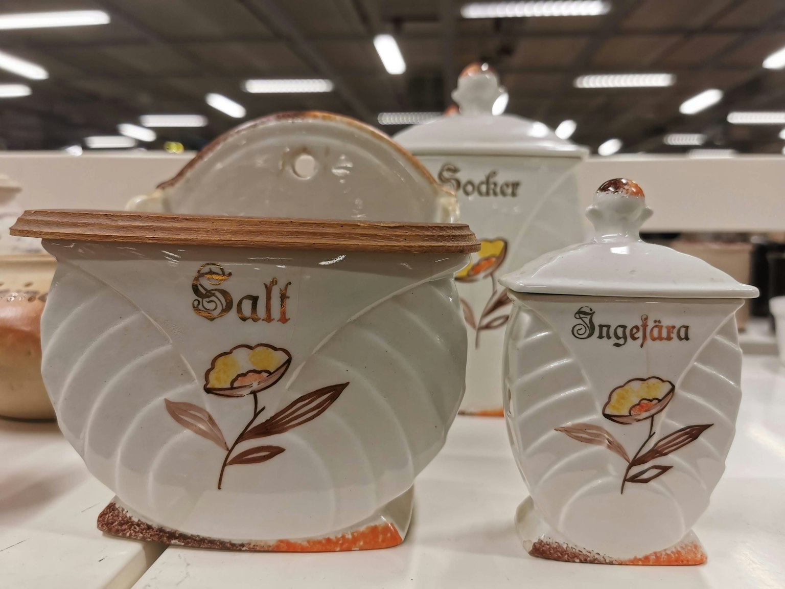Wadah keramik putih untuk garam dan rempah dengan desain bunga dan label dalam bahasa Inggris