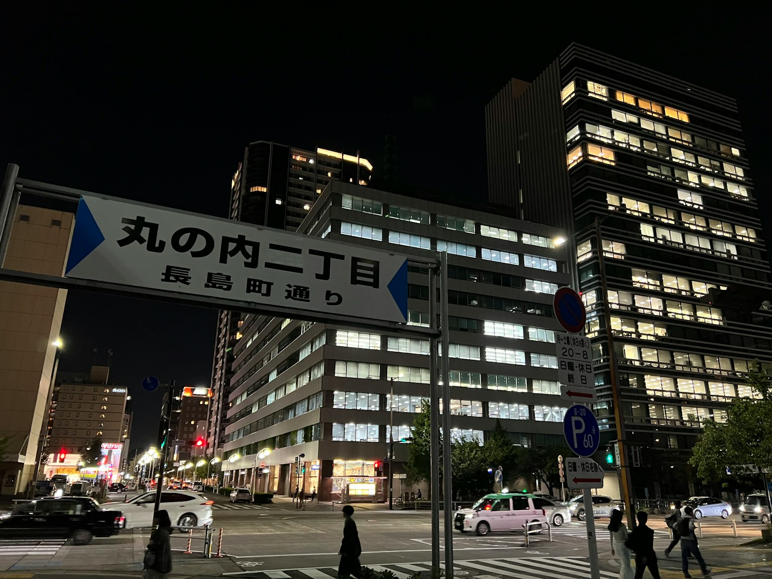 夜间交叉路口的街道标志和现代建筑