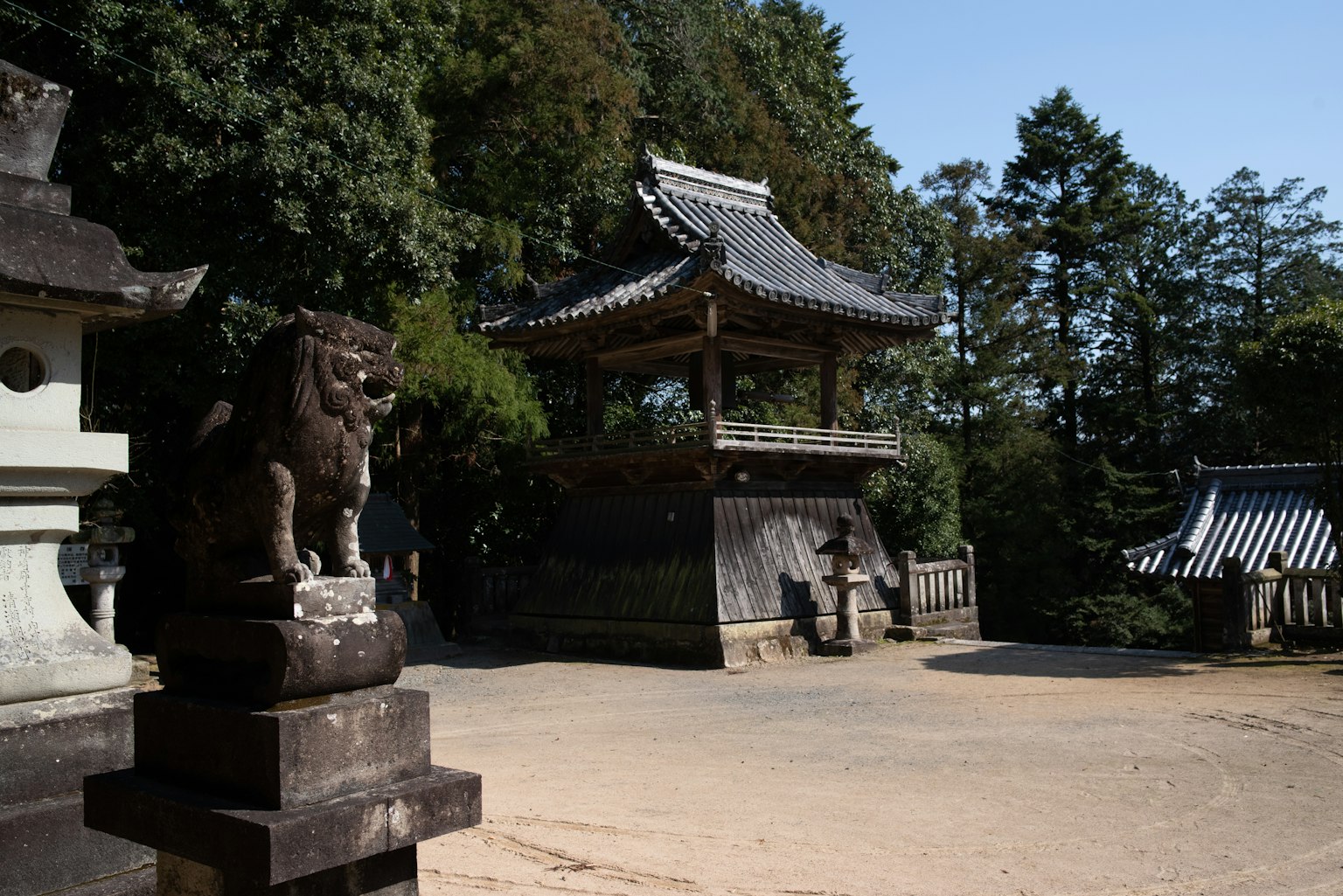 Scène tranquille d'un temple japonais avec une statue de chien-lion et une architecture traditionnelle