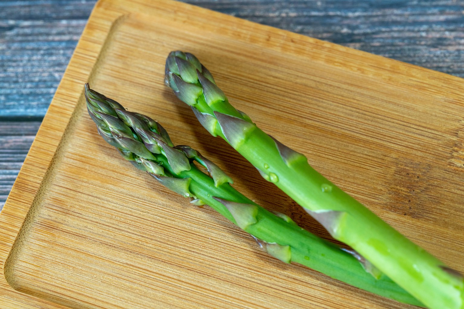 Fascio di asparagi freschi su un tagliere di legno
