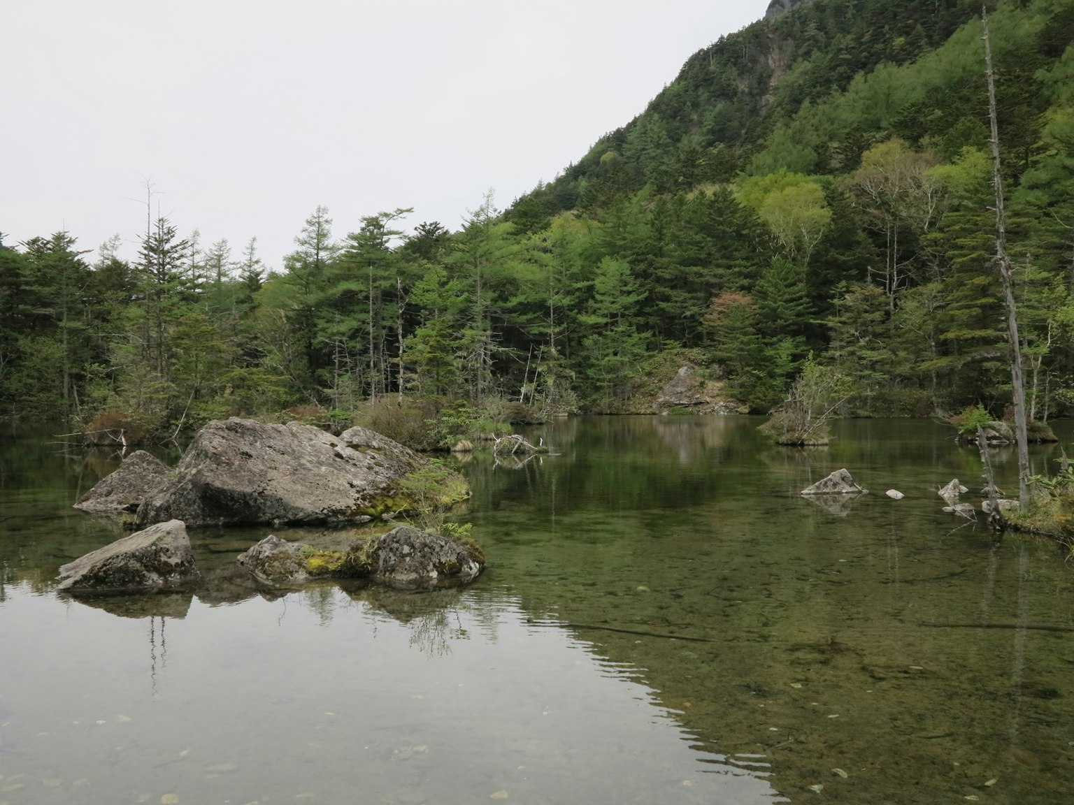 Scenic view of rocks and trees reflected in calm water