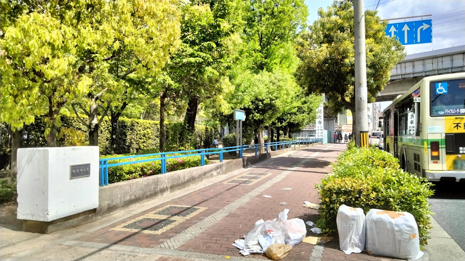 Una escena de calle vibrante con vegetación exuberante y una parada de autobús