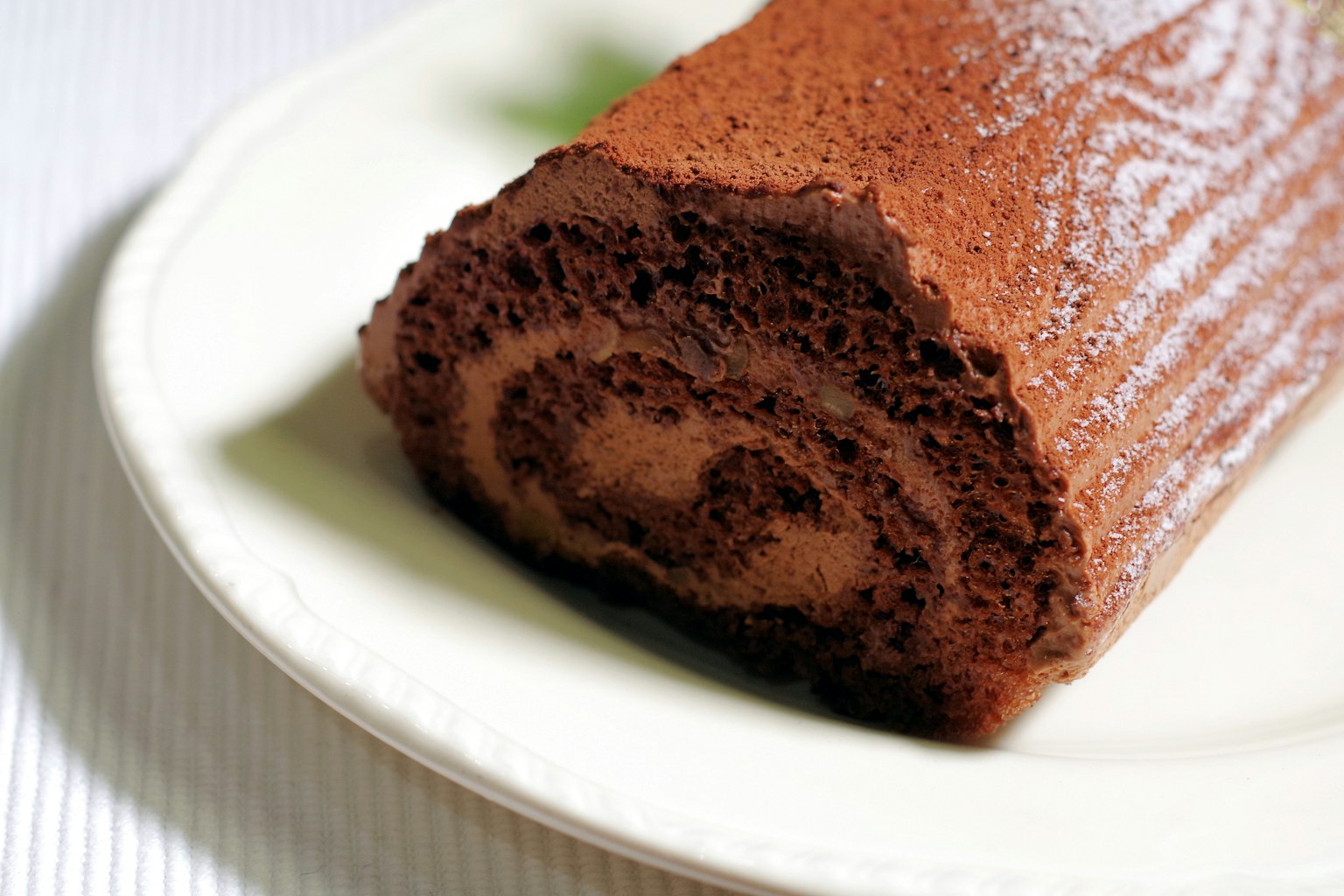 A close-up of a chocolate roll cake showcasing its rich chocolate layers and creamy swirl