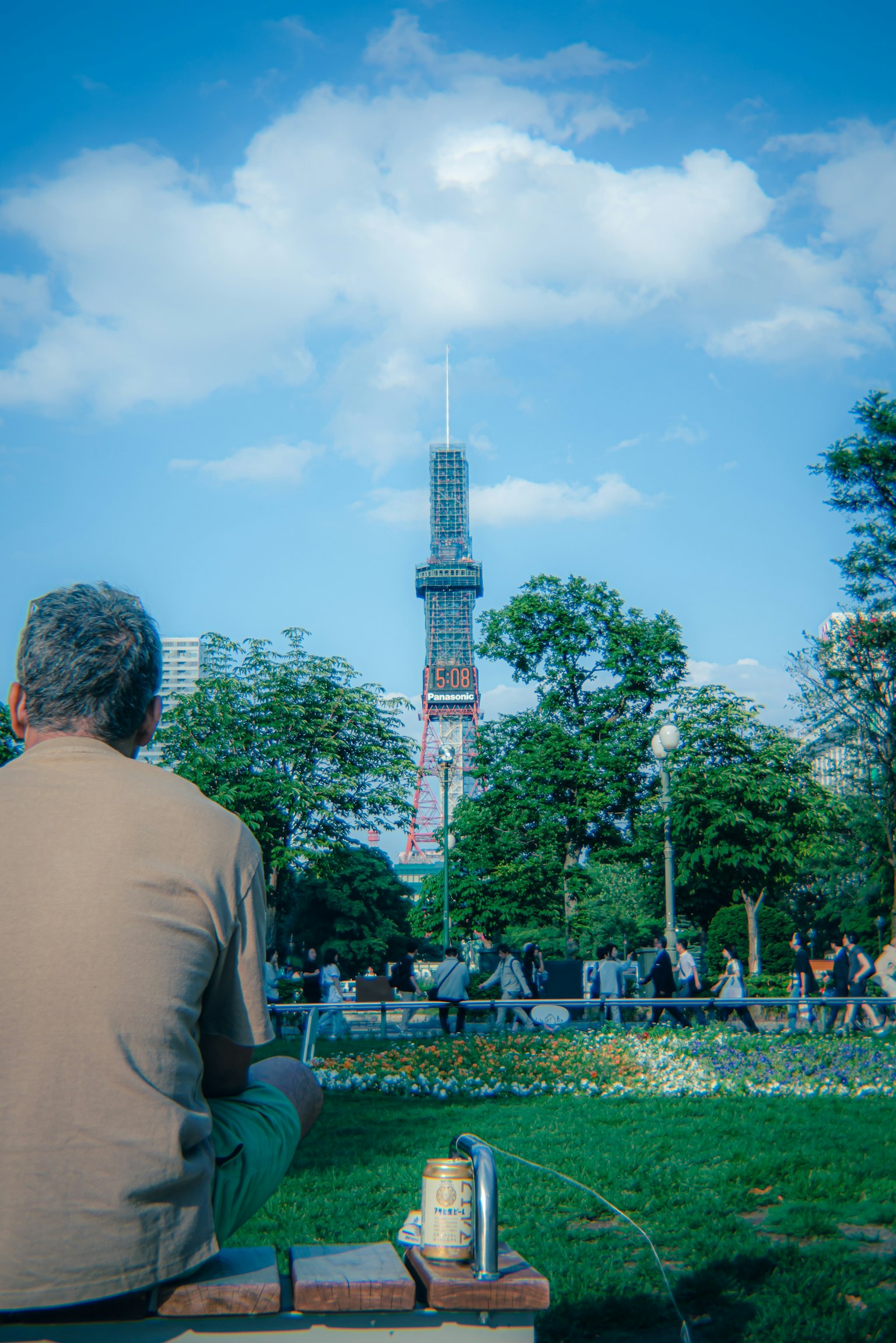 Uomo seduto in un parco con la Tokyo Skytree sullo sfondo