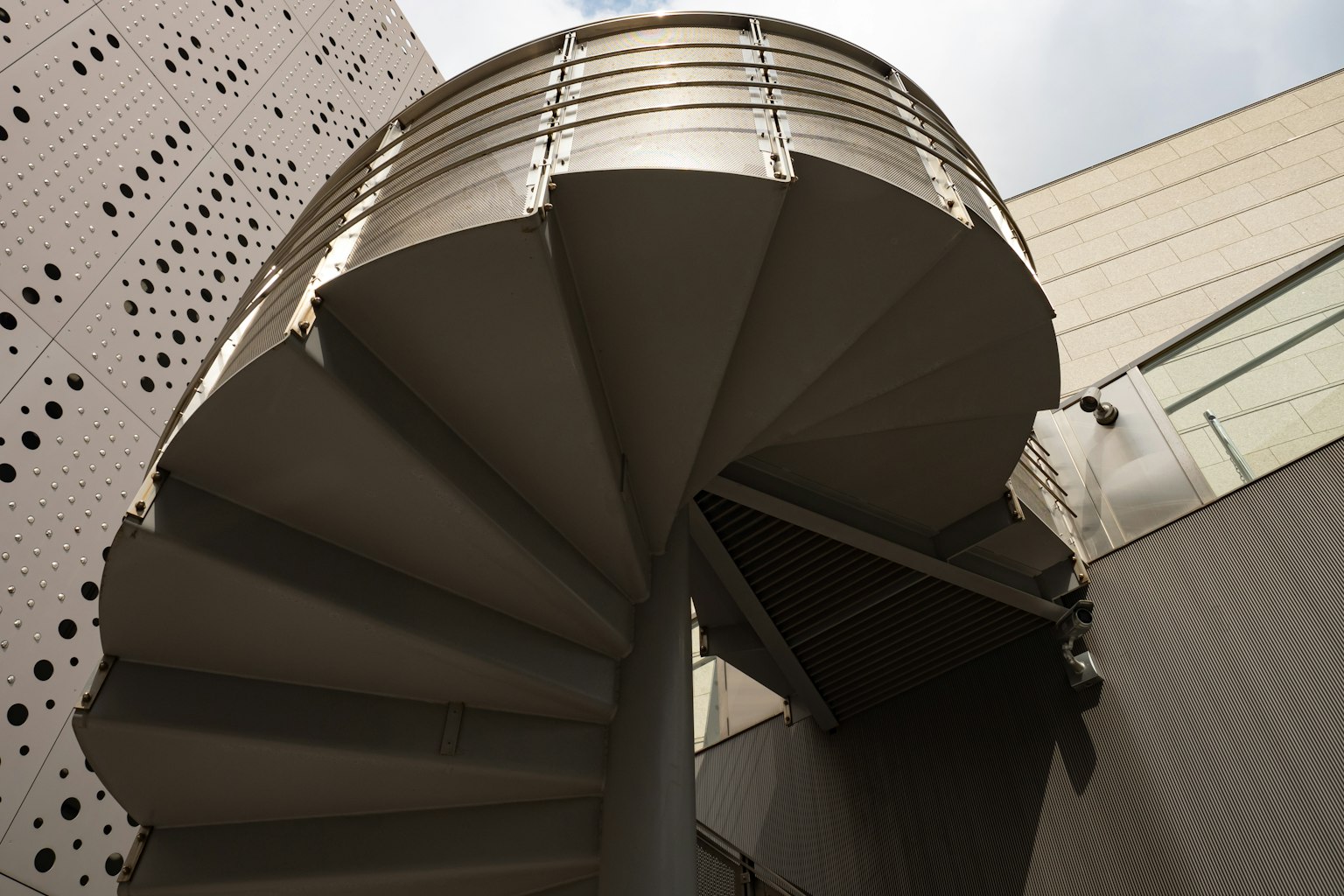 Tangga spiral logam yang naik di dalam lingkungan arsitektur modern