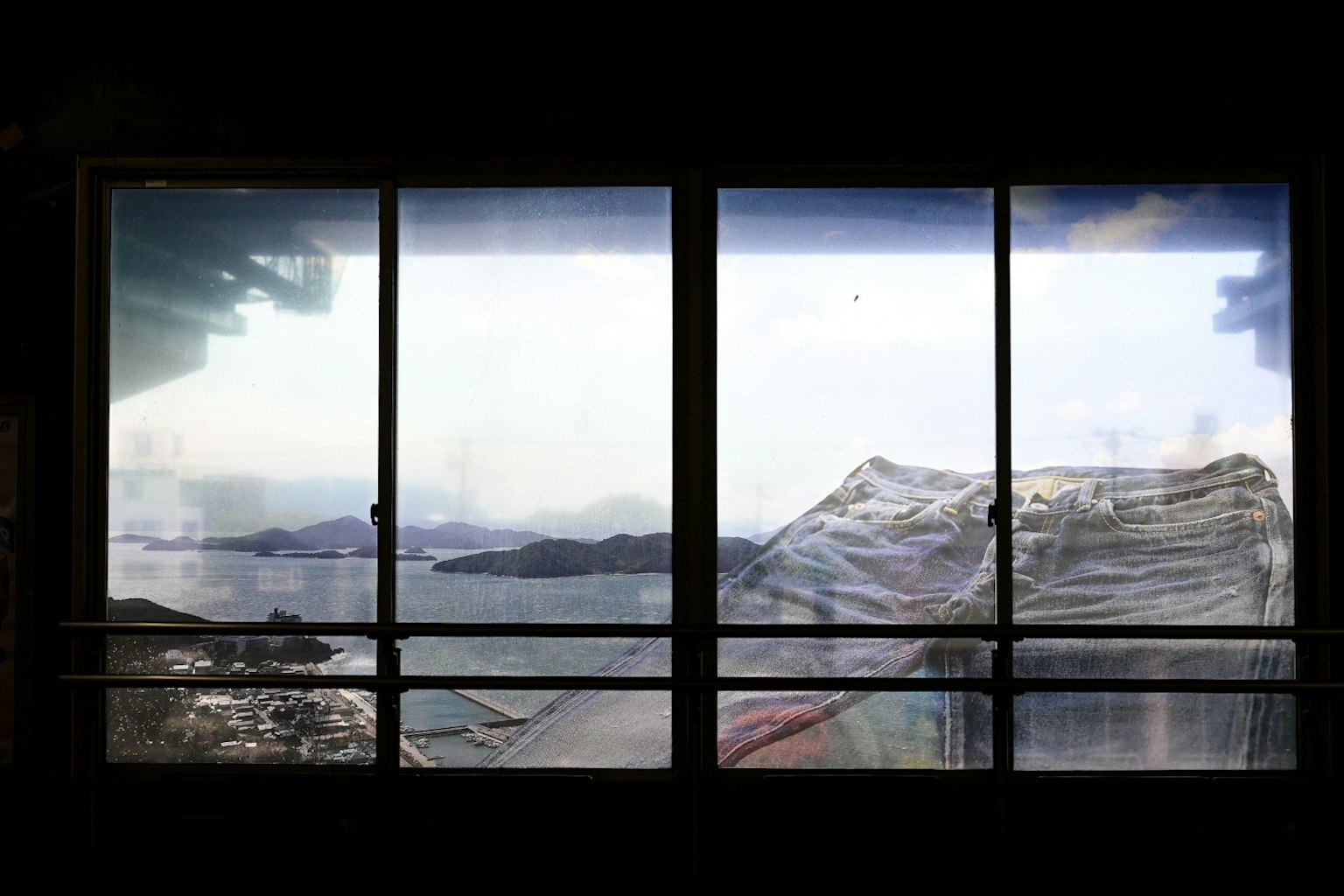 窓越しに見える海と山の風景