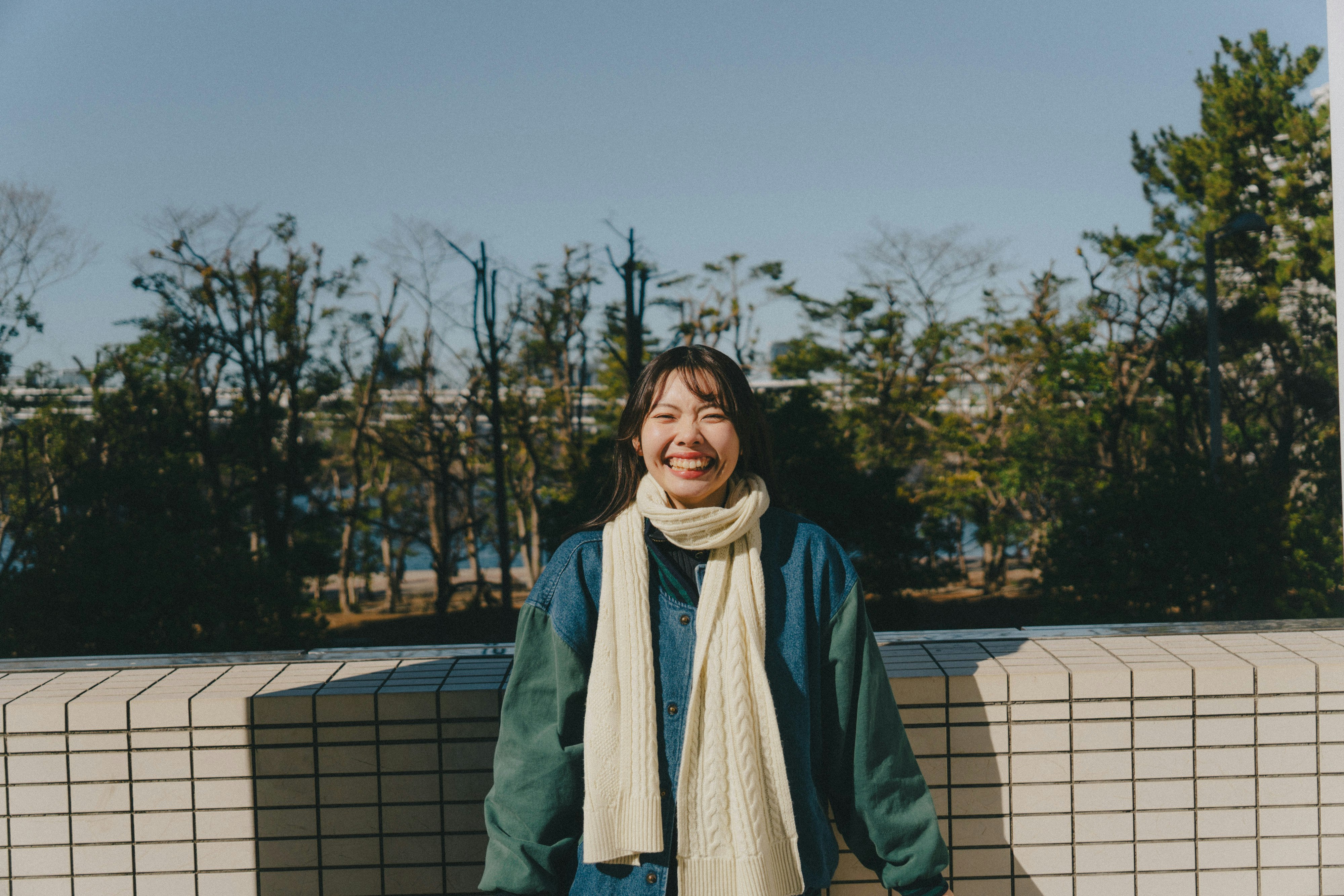 屋外の遊歩道で微笑む女性