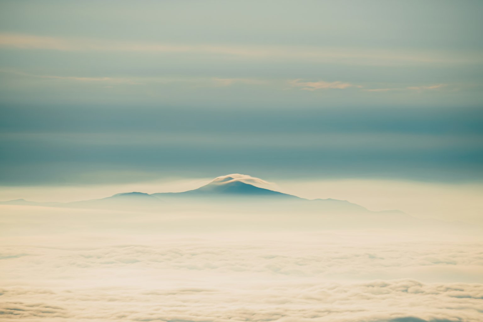 Cima di montagna visibile attraverso un mare di nebbia