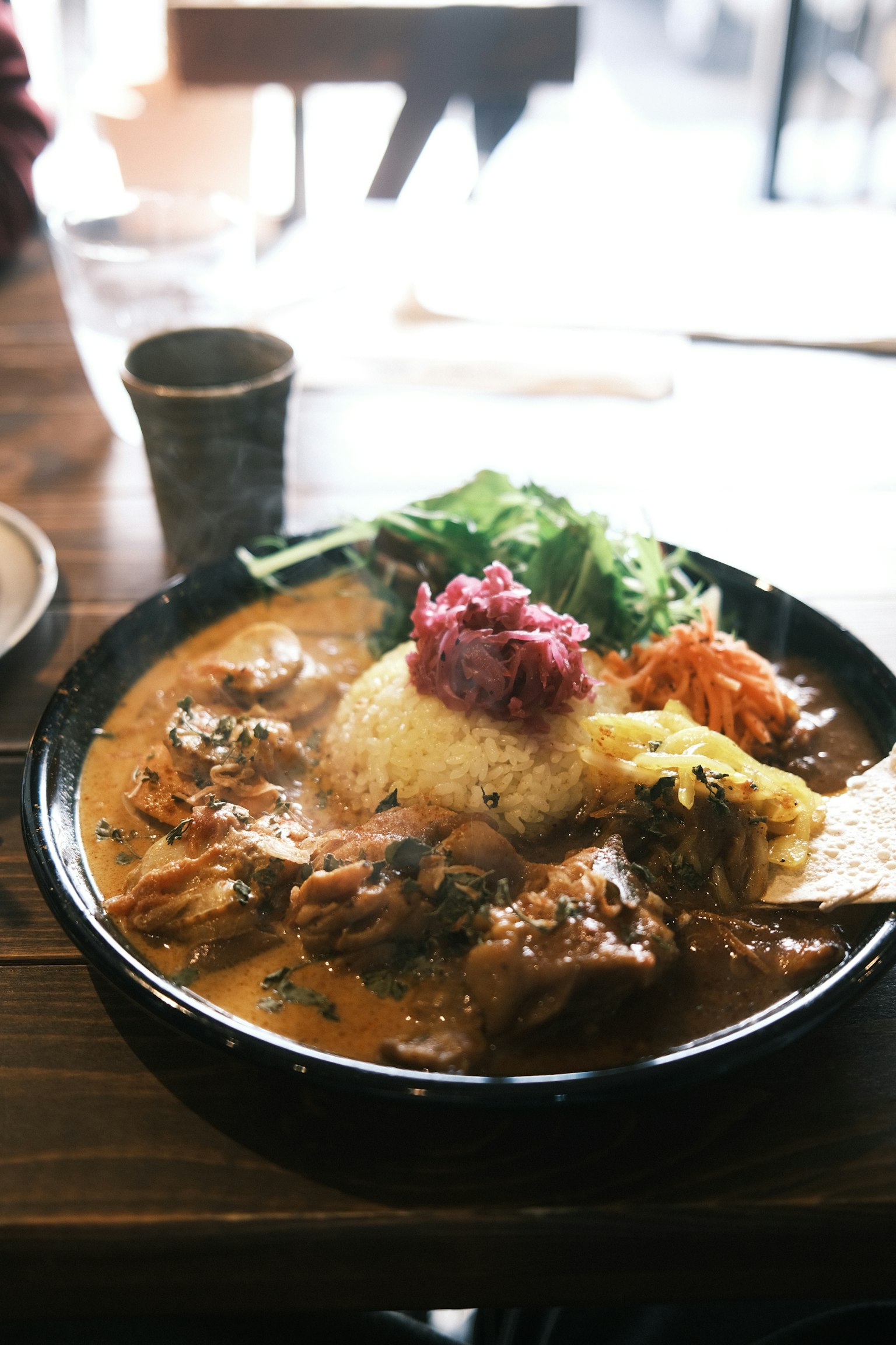Dish featuring chicken in spicy curry sauce served with rice and vegetables