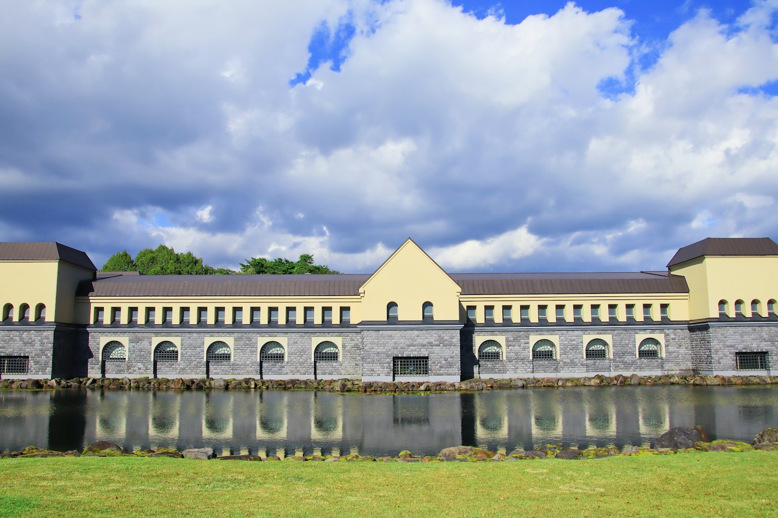 Stone building reflecting in water surrounded by lush greenery