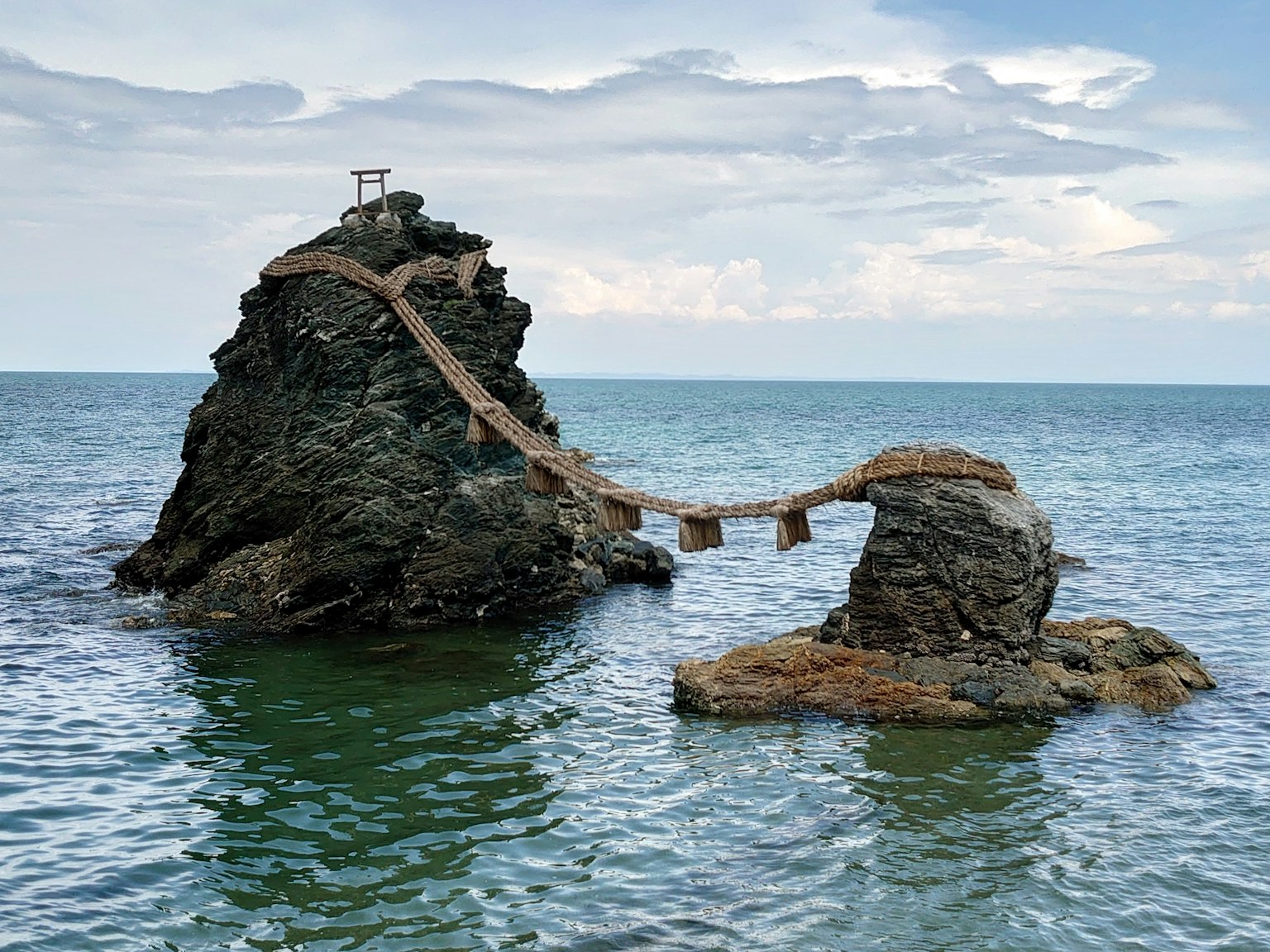 Vue pittoresque de rochers reliés par un pont en bois sur la mer