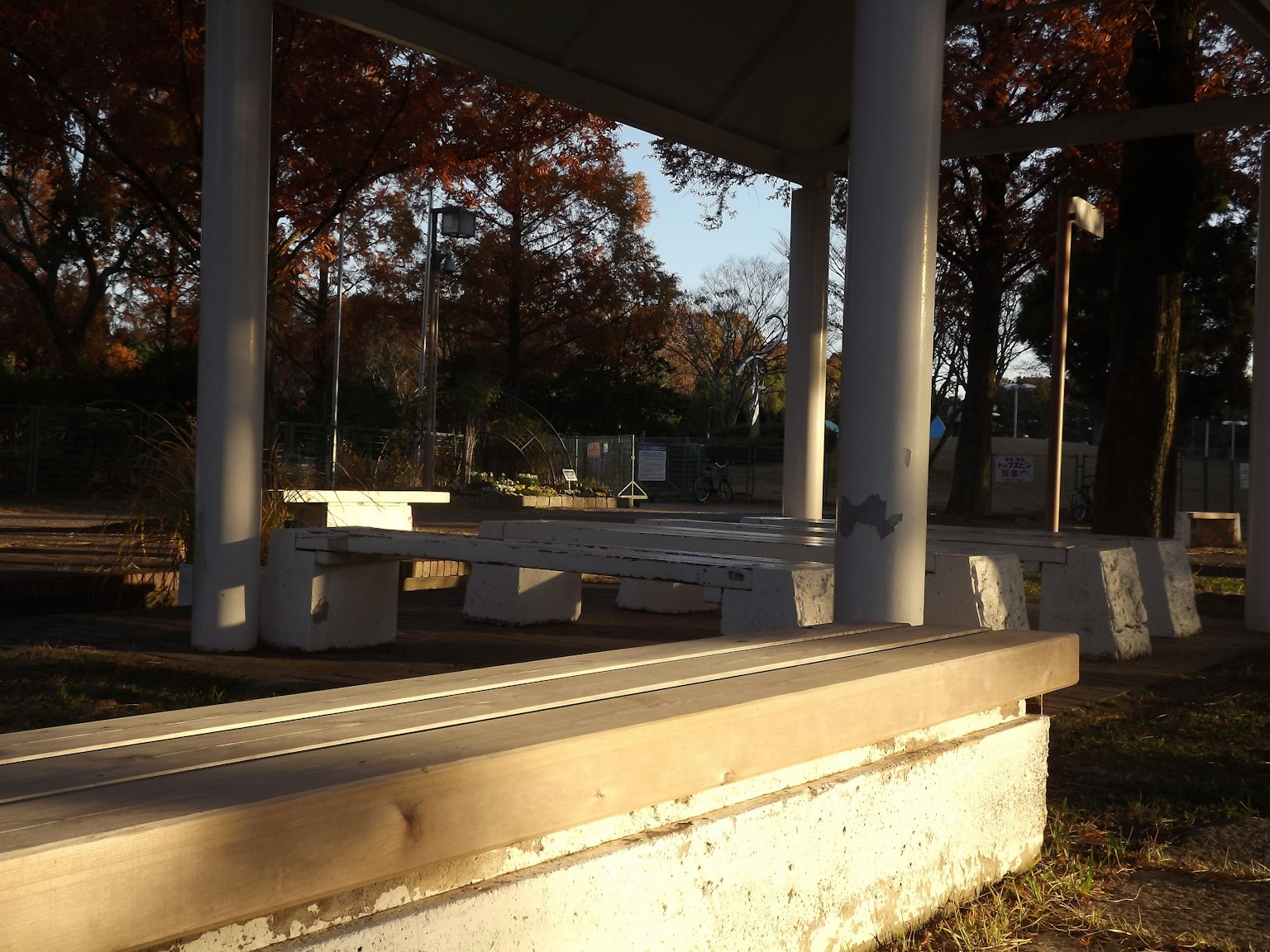 Foto de un pabellón del parque con bancos circundantes follaje de otoño de fondo