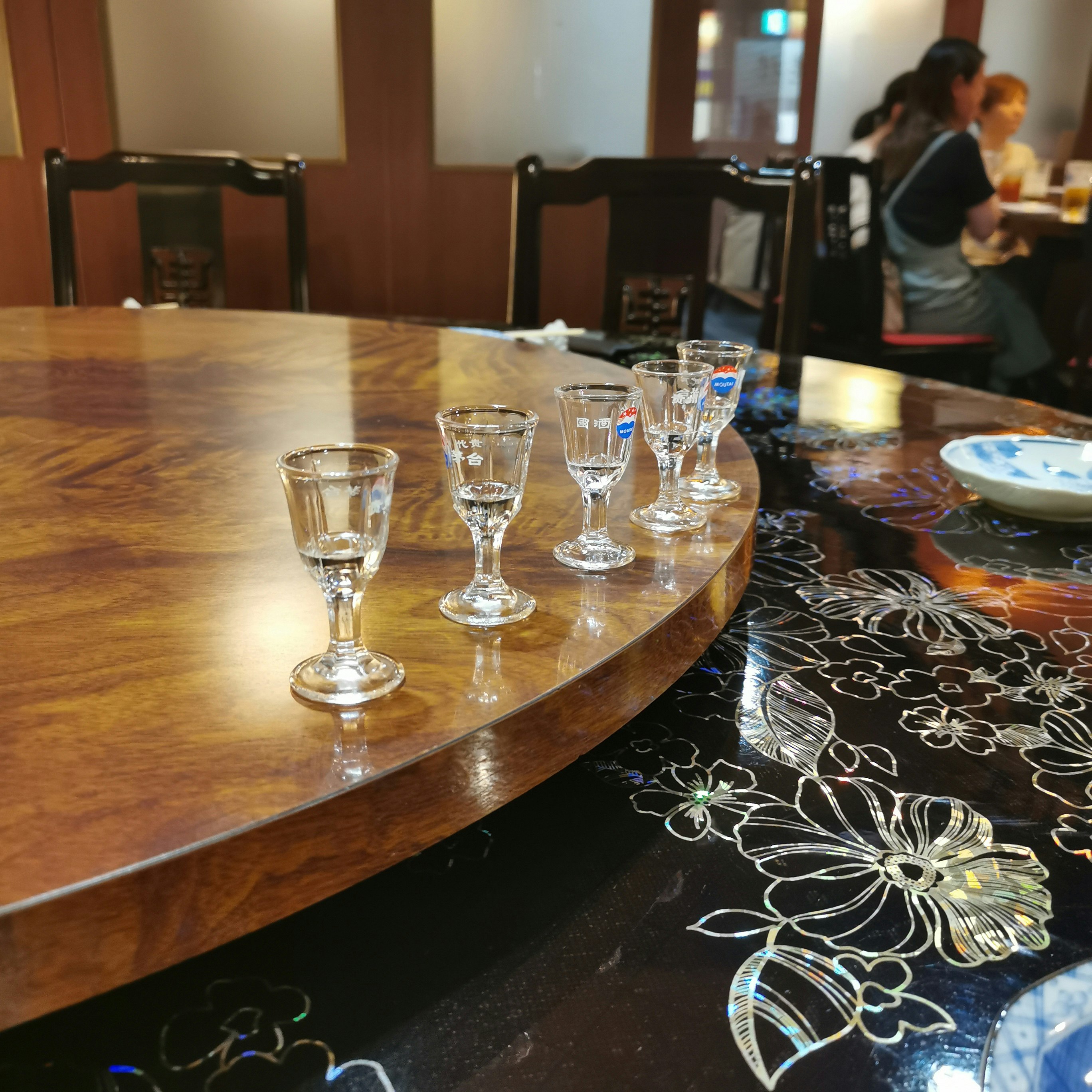 Indoor dining scene with glasses and tableware on a wooden table