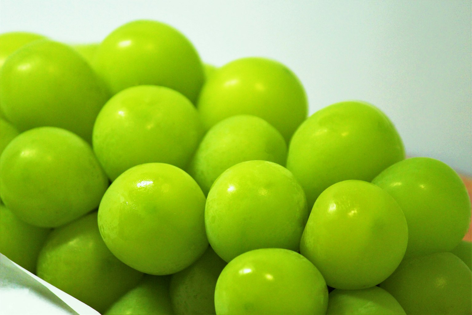 A cluster of vibrant green grapes arranged closely together