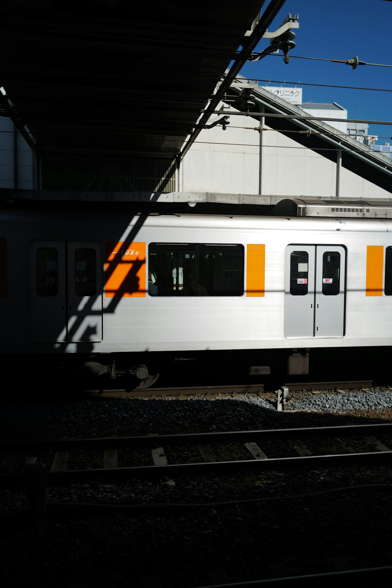 รถไฟขาวที่มีสีส้มจอดอยู่ที่ชานชาลาสถานี