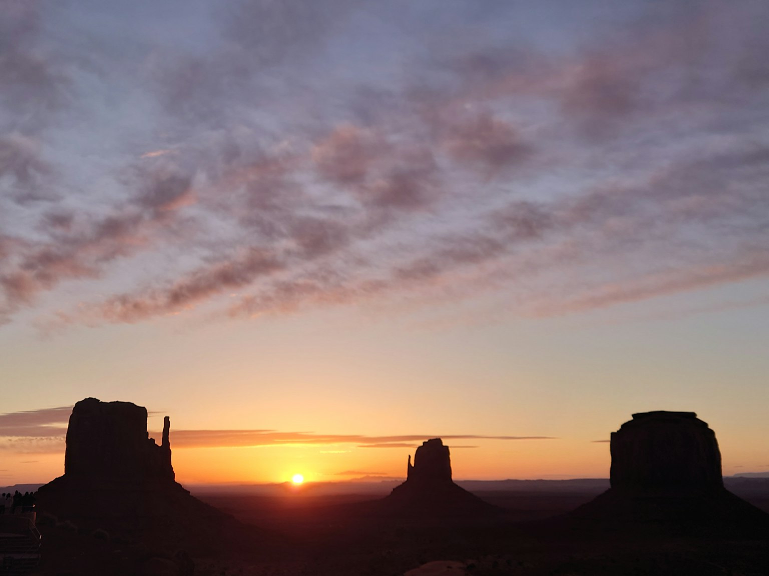 Sonnenuntergang über Monument Valley mit silhouettierten Felsformationen