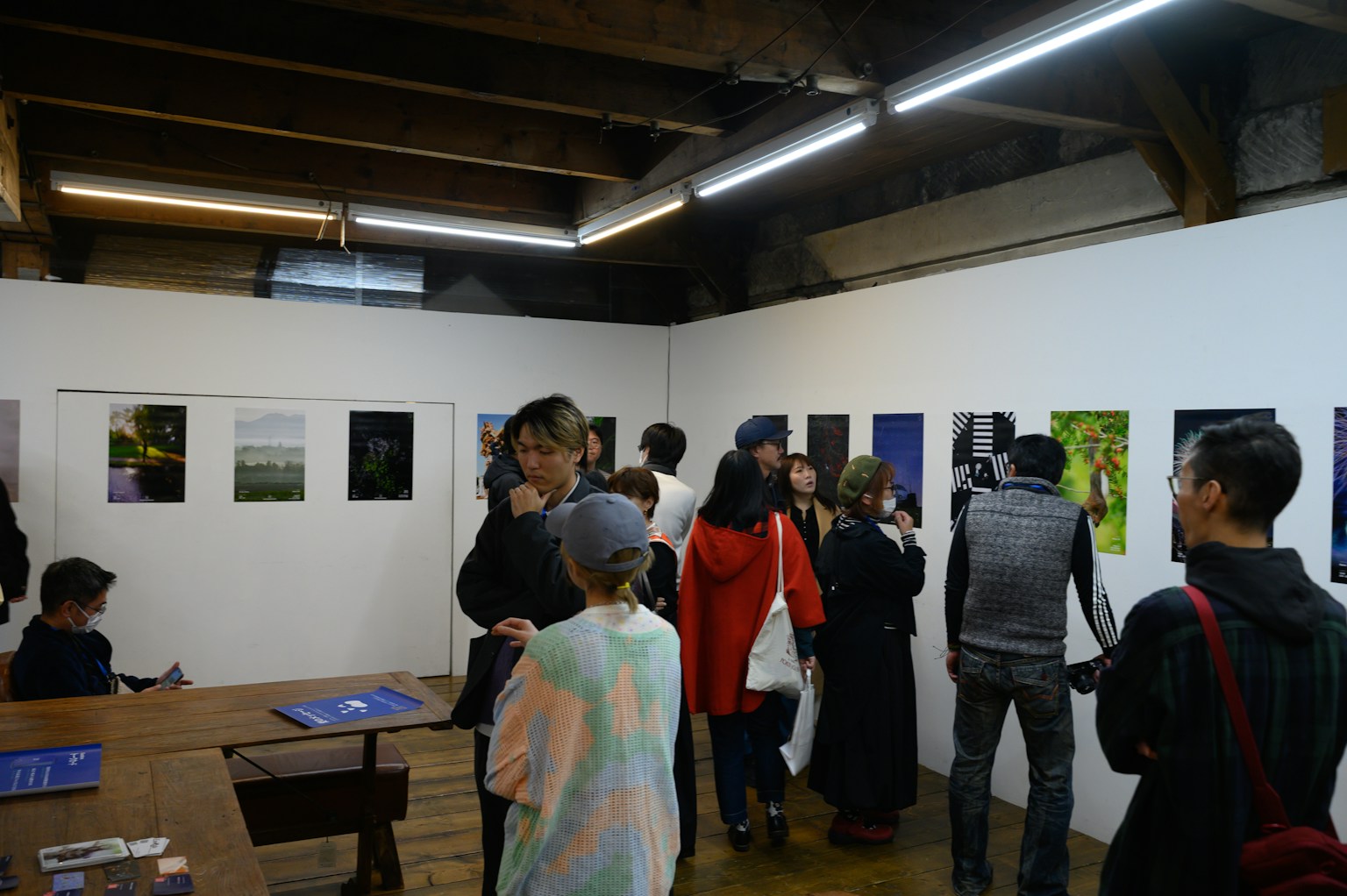 参观者聚集在艺术画廊中观看展示的各种照片