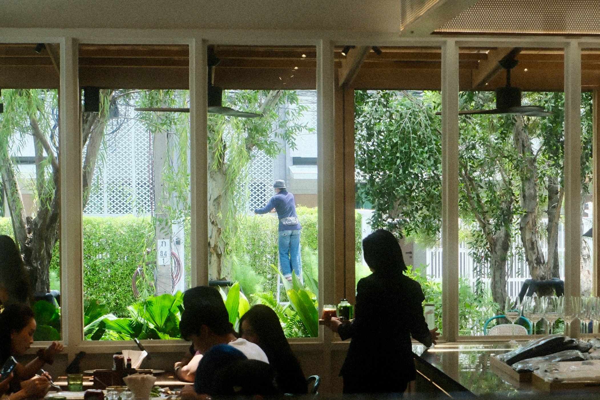 大きな窓のある室内で食事をする人々