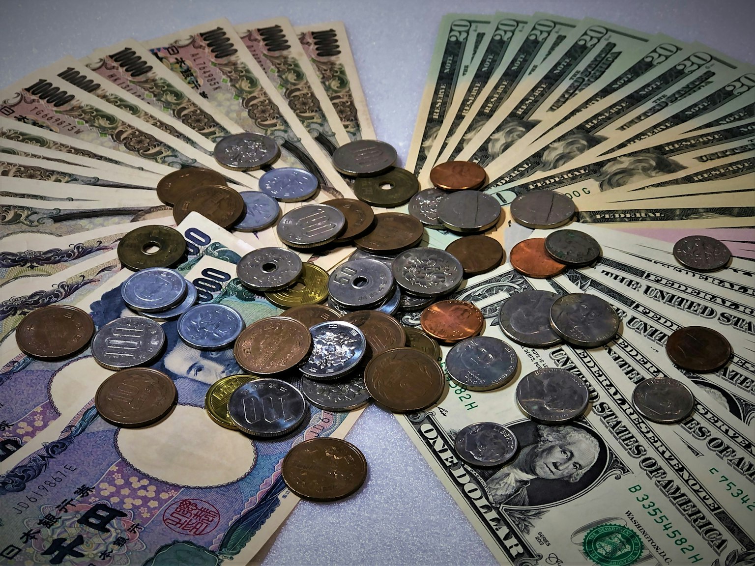 Image montrant un mélange de billets et de pièces en yen japonais et en dollars américains