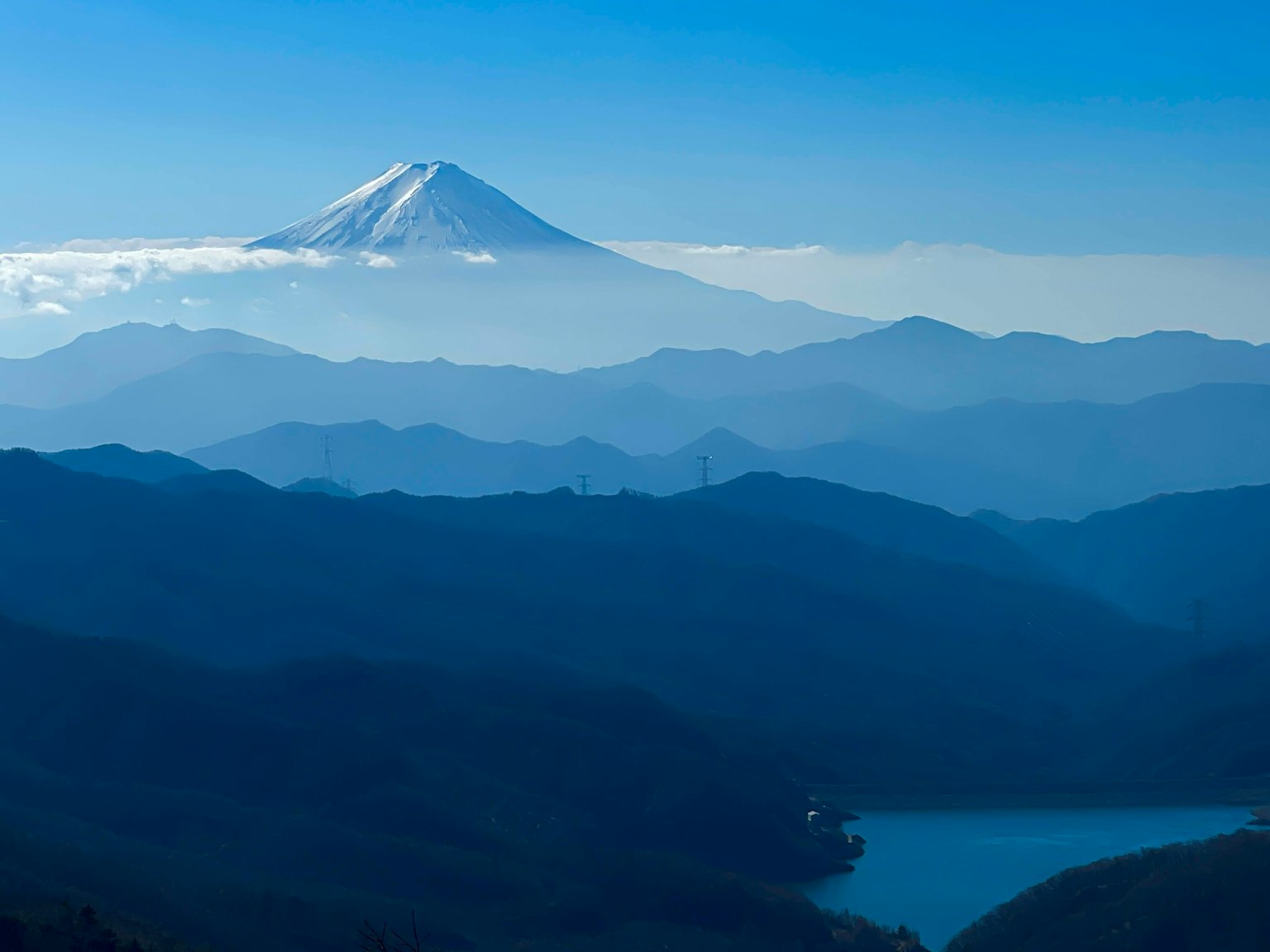 Mount Fuji visible between blue sky and mountains