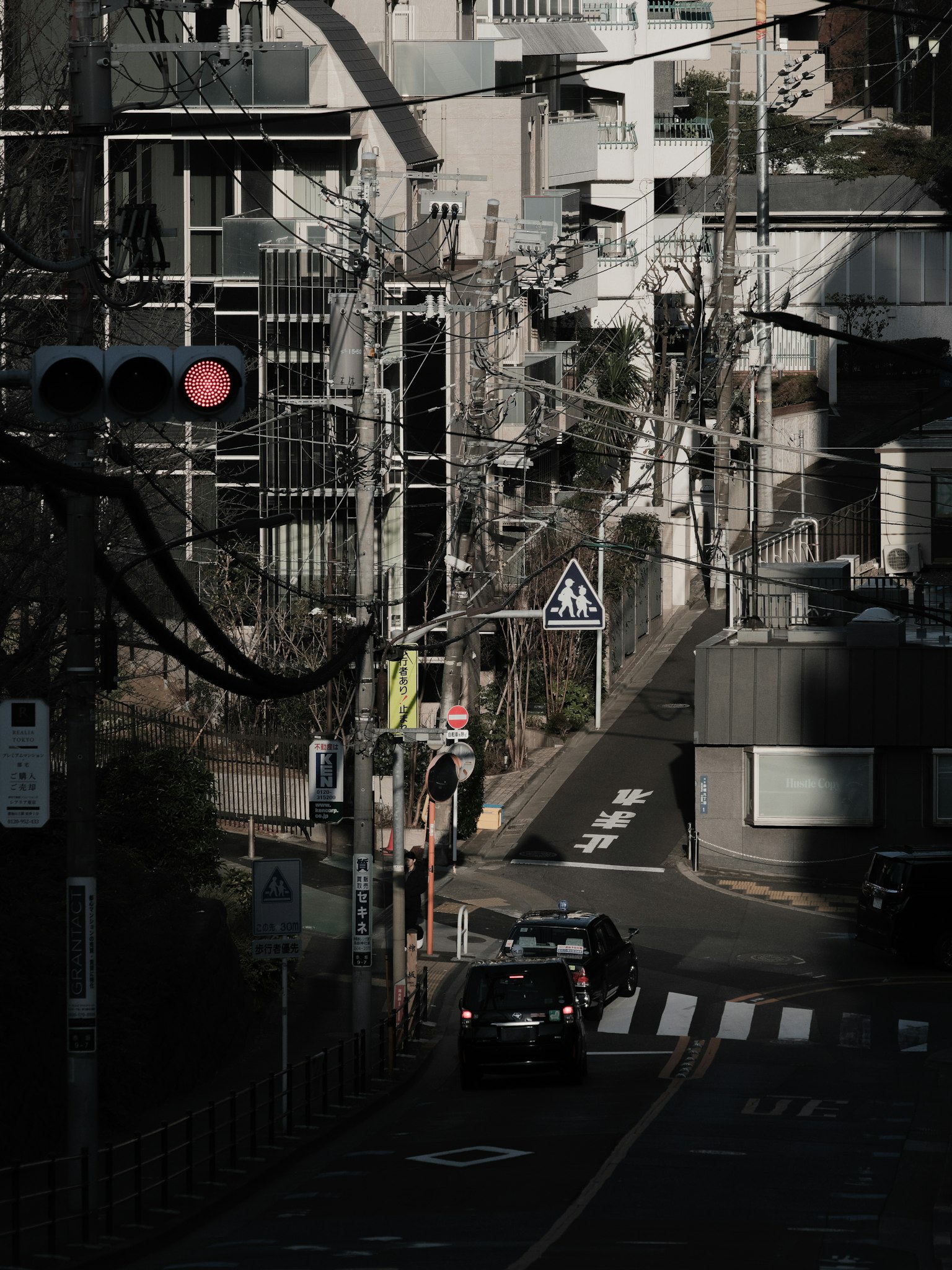 城市街道场景一辆车在狭窄的道路上行驶周围是高楼和电线杆