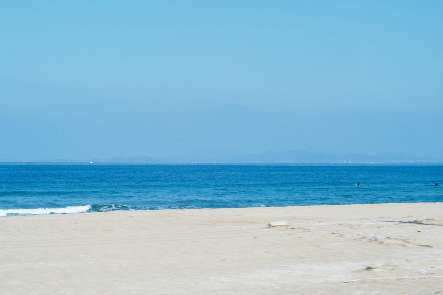 Escena de playa con cielo azul claro y océano