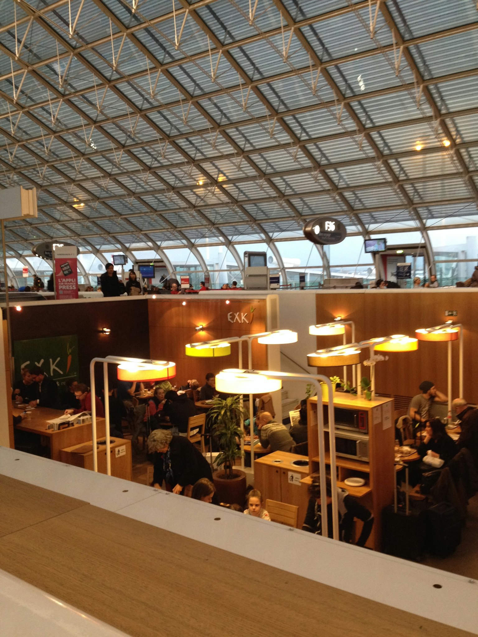 Bright indoor cafe scene with tables featuring lamps and plants