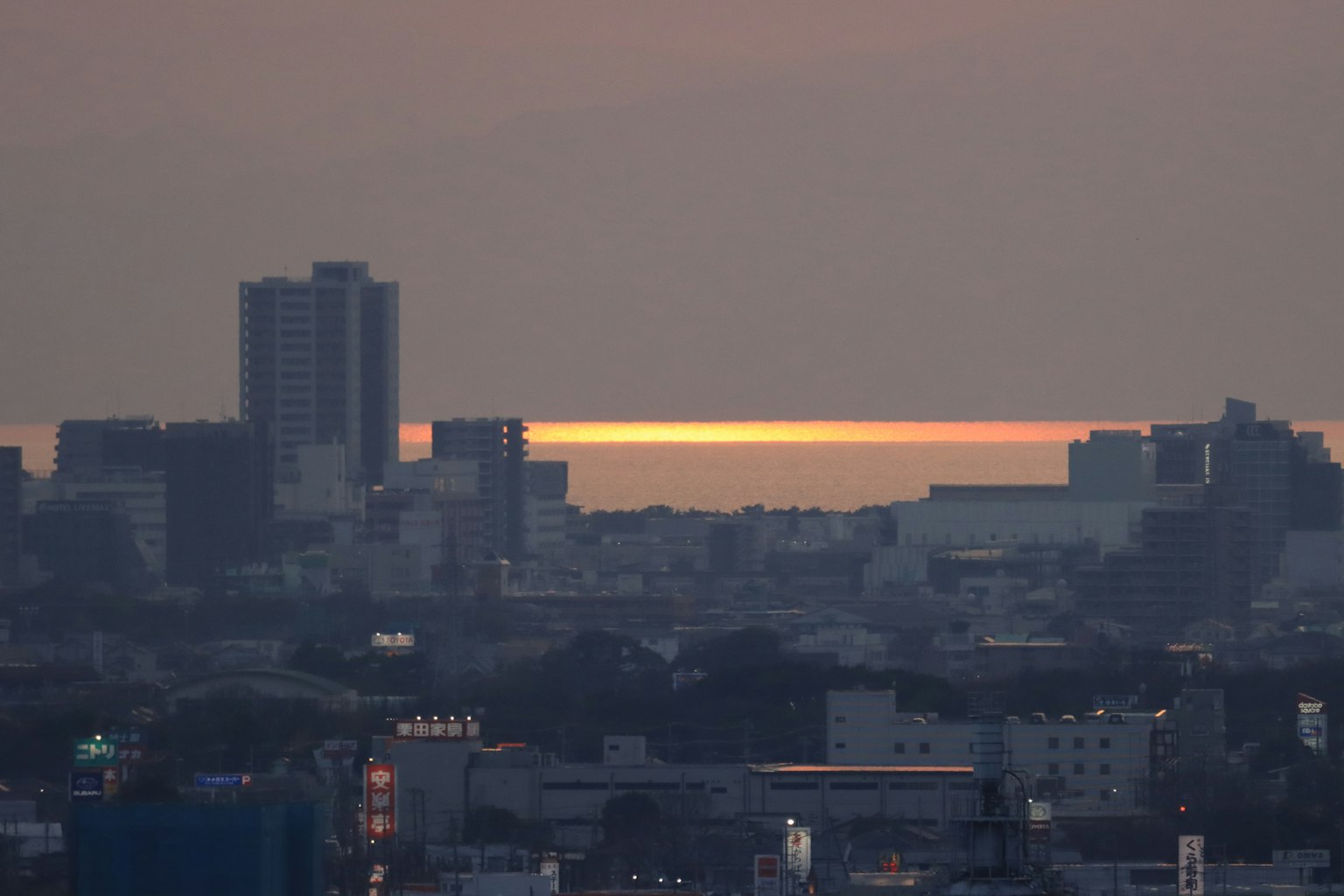 Cityscape with sunset reflecting on the ocean