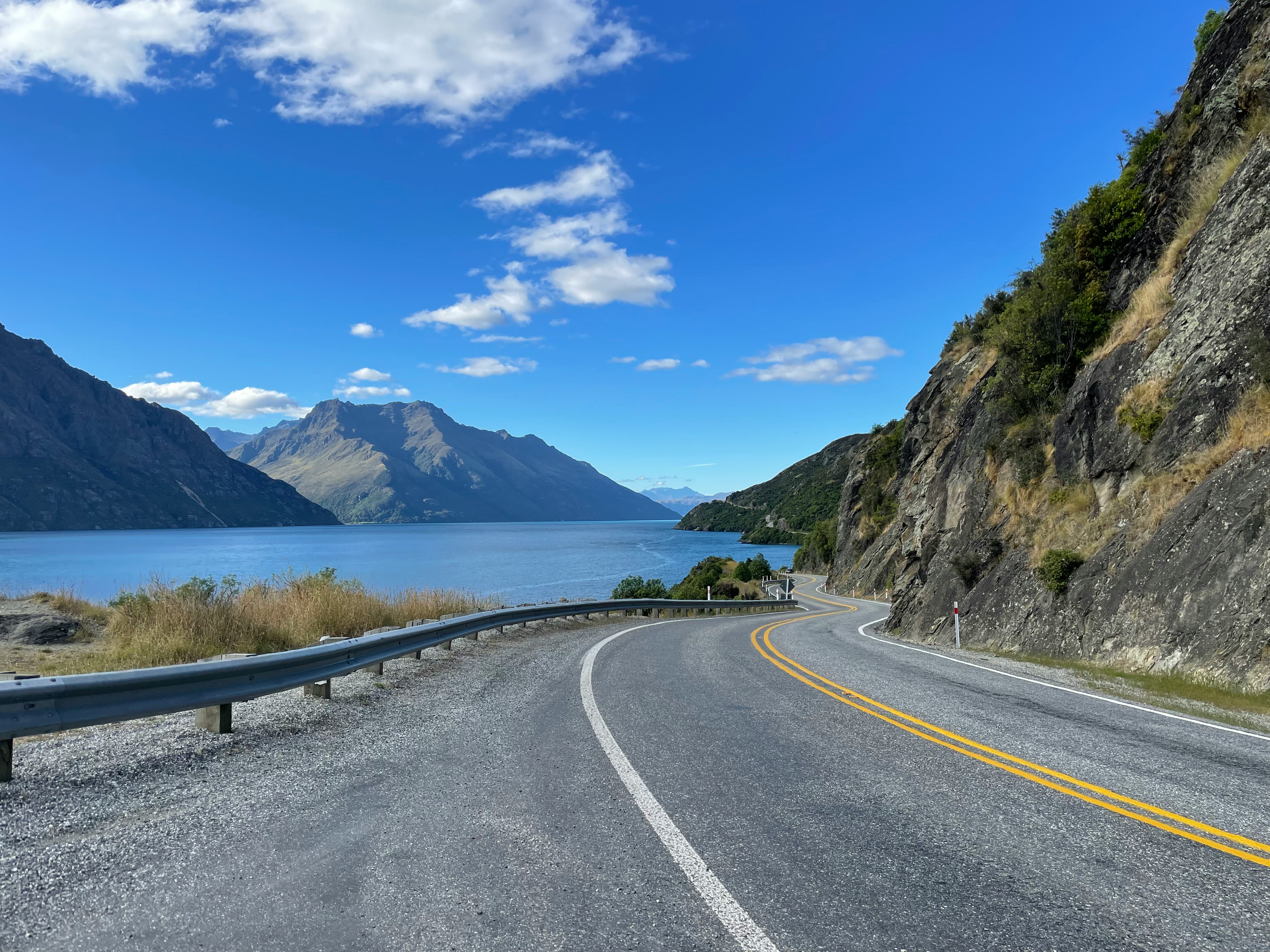 carretera sinuosa junto a un lago de montaña