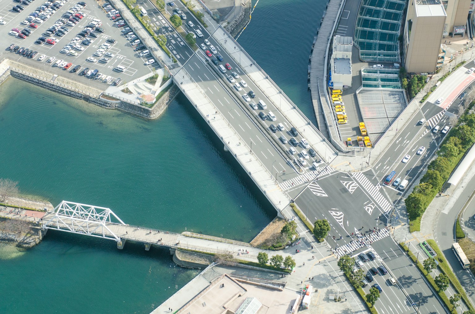 Vue aérienne d'un carrefour et d'un pont près d'un parking et de l'eau