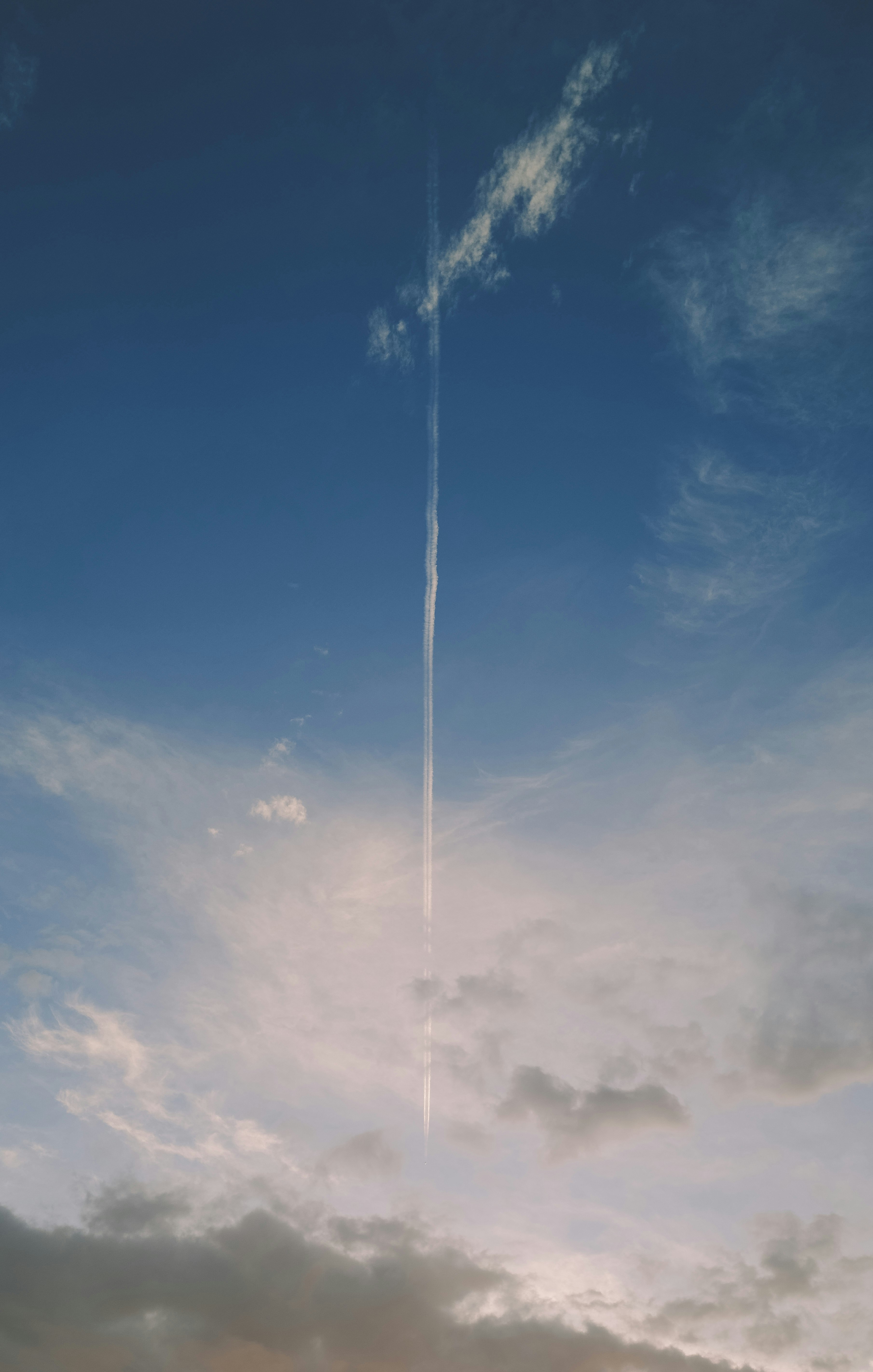 天空中细长的凝结尾迹般云带与暮色云层