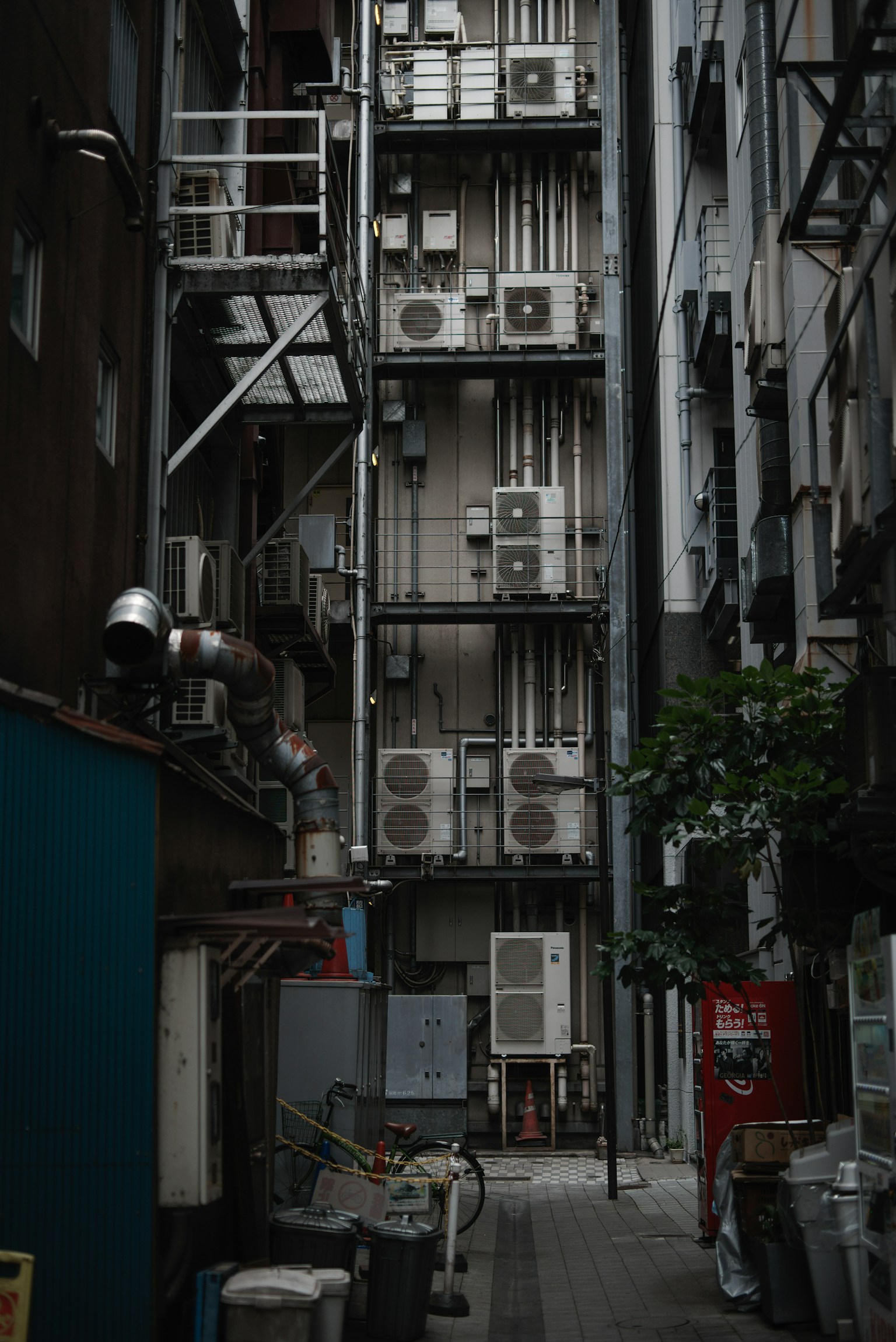 ตรอกแคบที่มีเครื่องปรับอากาศและผนังอาคารเรียงราย