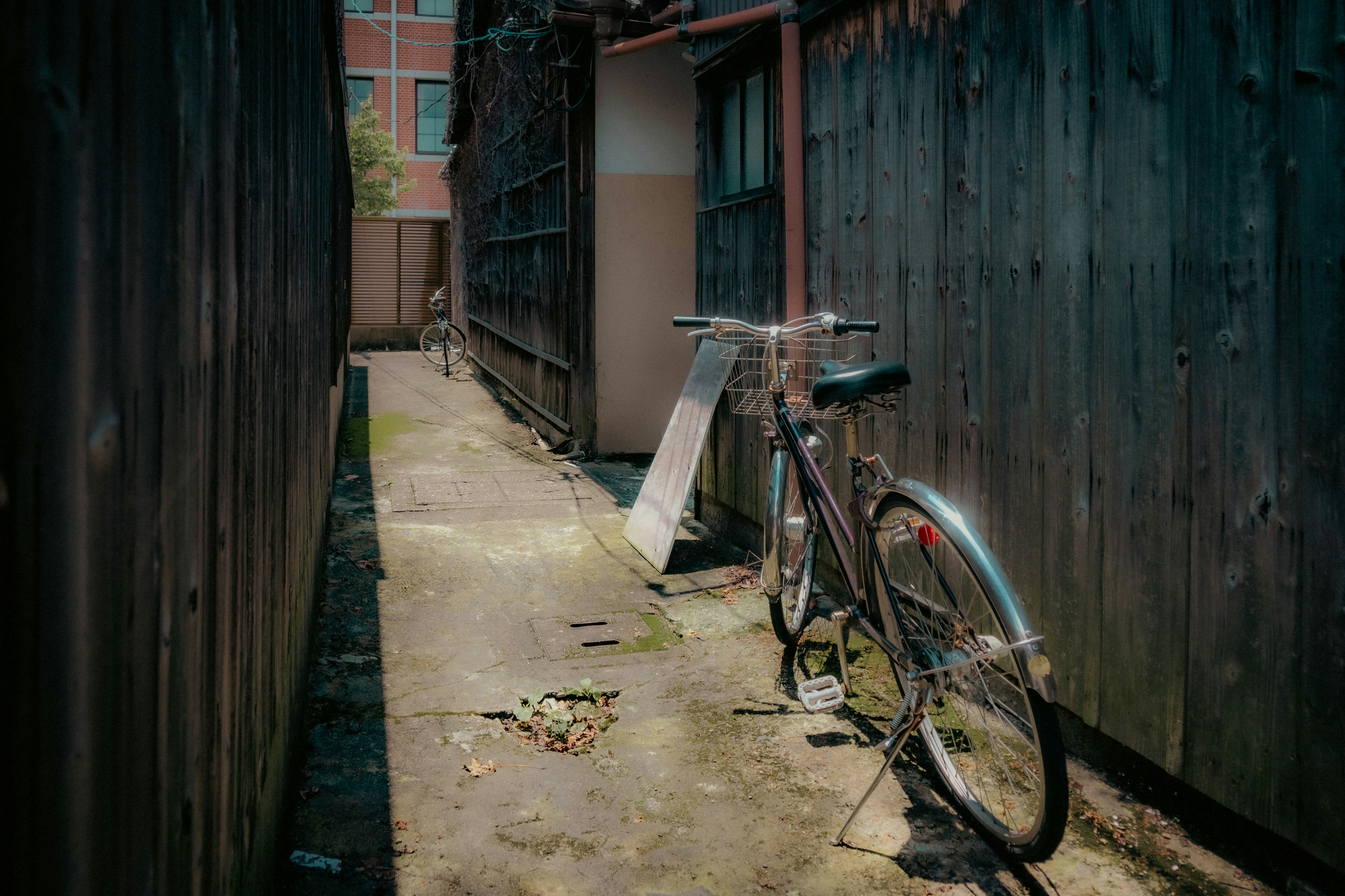 路地に並ぶ自転車と店先のような壁面