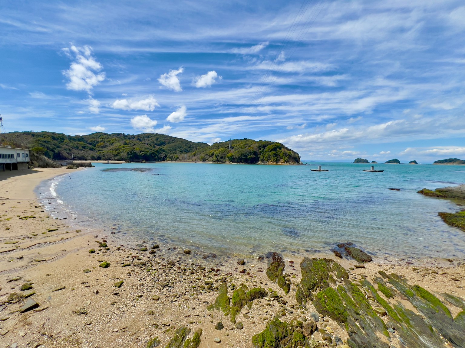 Pemandangan pantai yang indah dengan air biru jernih dan garis pantai berbatu