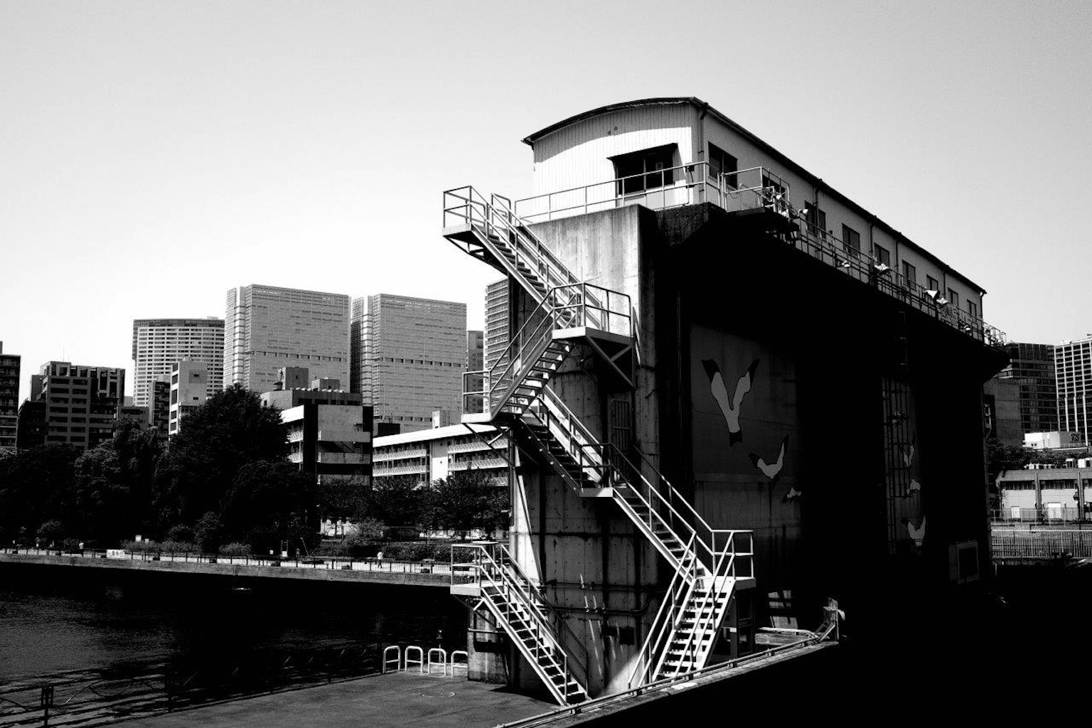 Bâtiment industriel avec escaliers dans un paysage urbain en noir et blanc