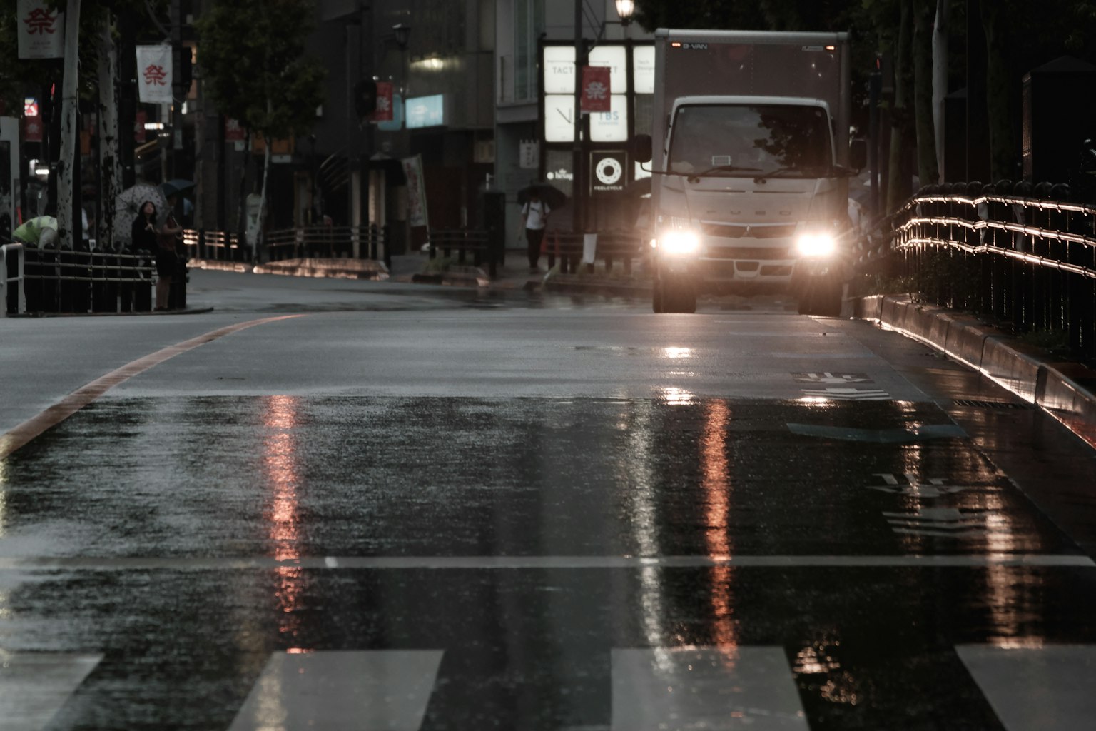 Night scene of a wet street with a vehicle driving