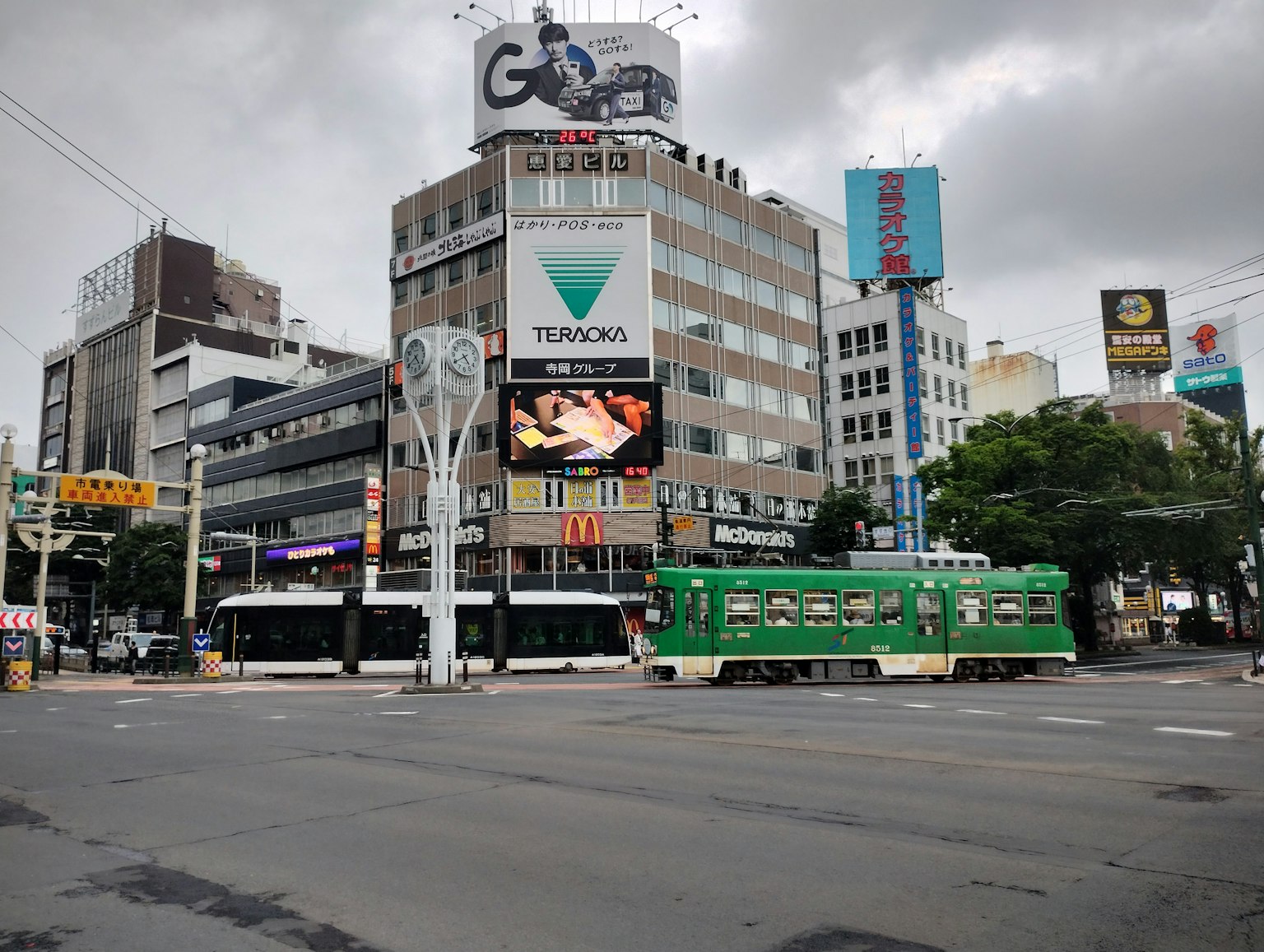 城市交叉口，綠色電車和周圍建築