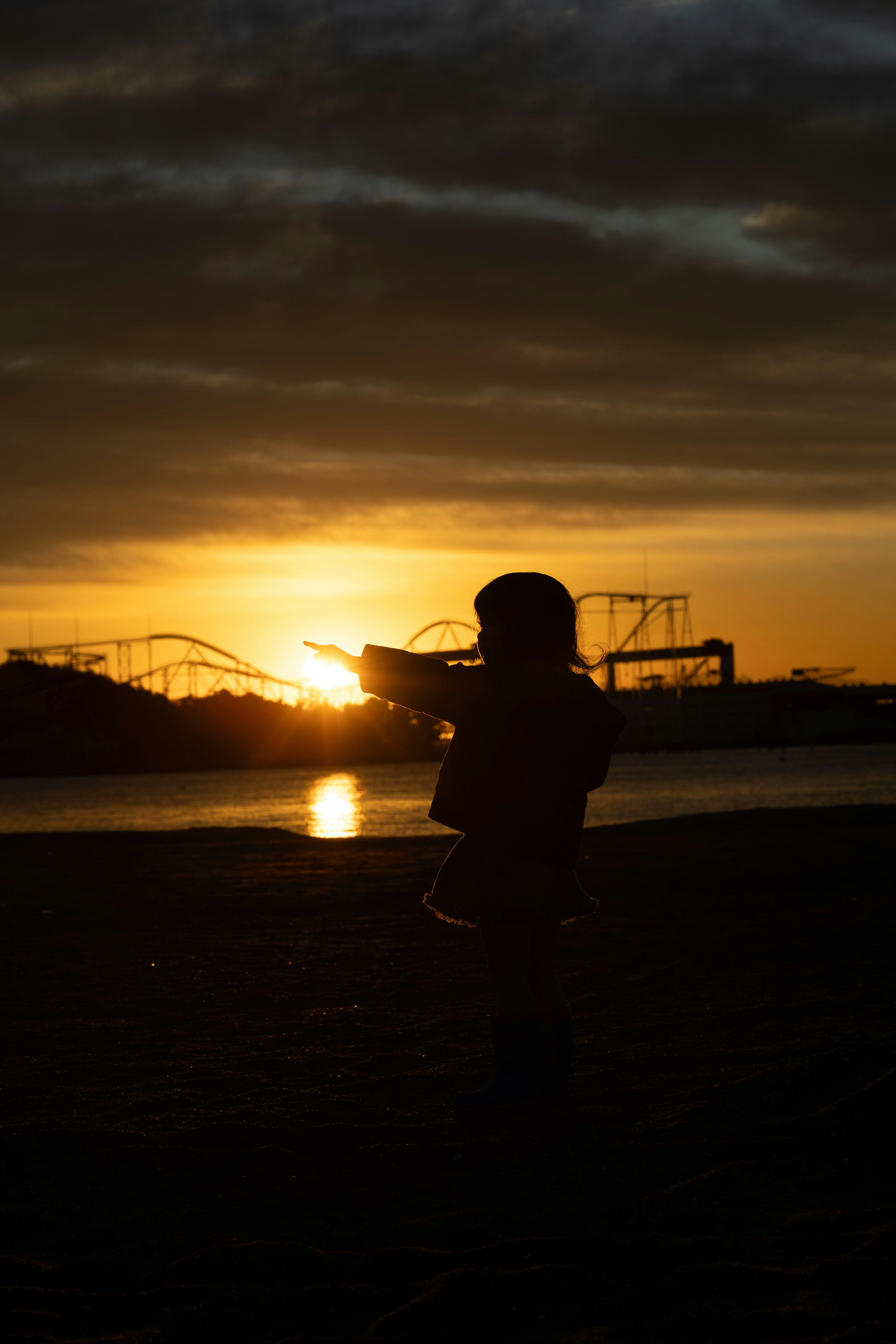 silhouette seseorang berlari di tepi pantai saat matahari terbenam