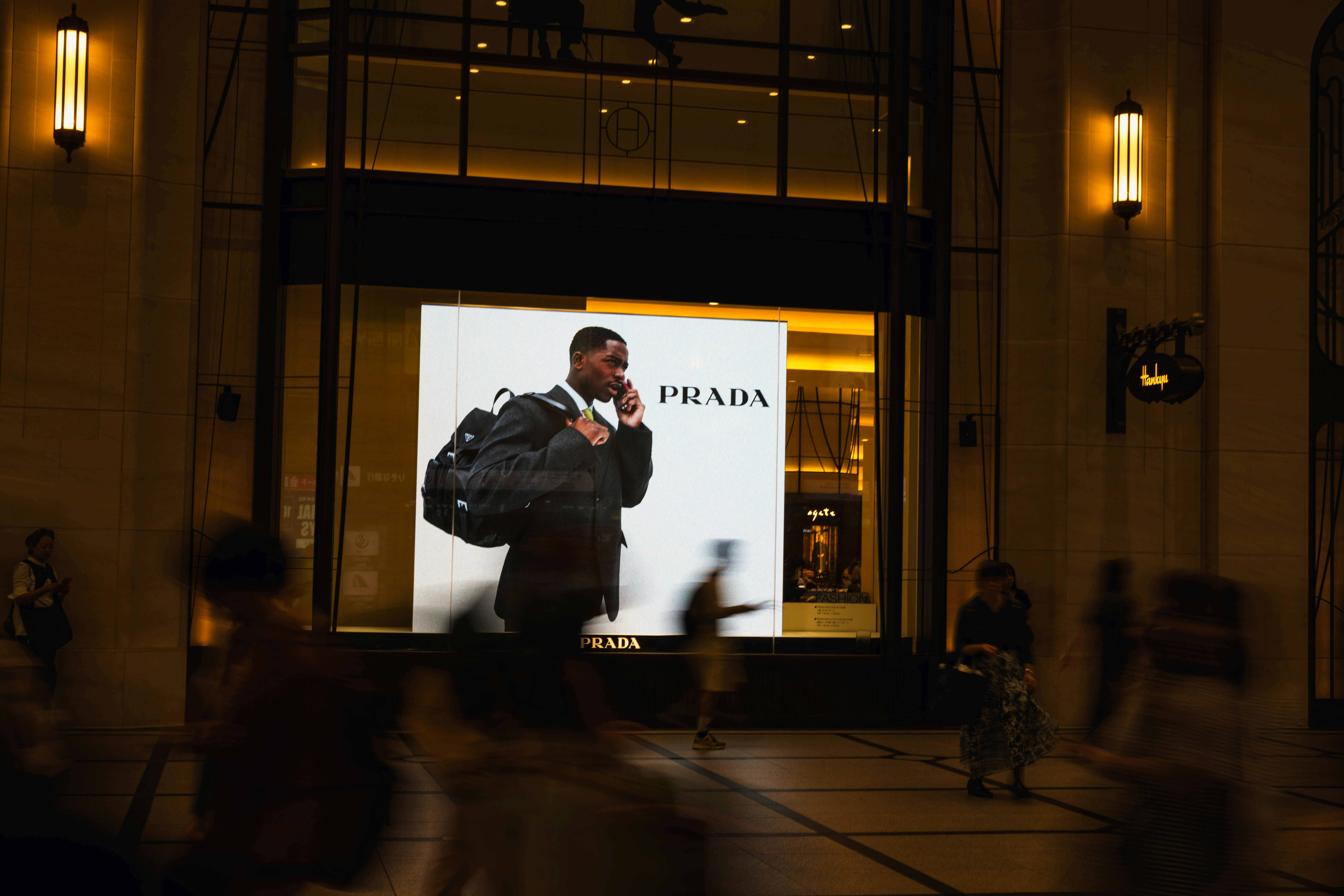 ショーウィンドウ前で歩く人々のある夜の街並み