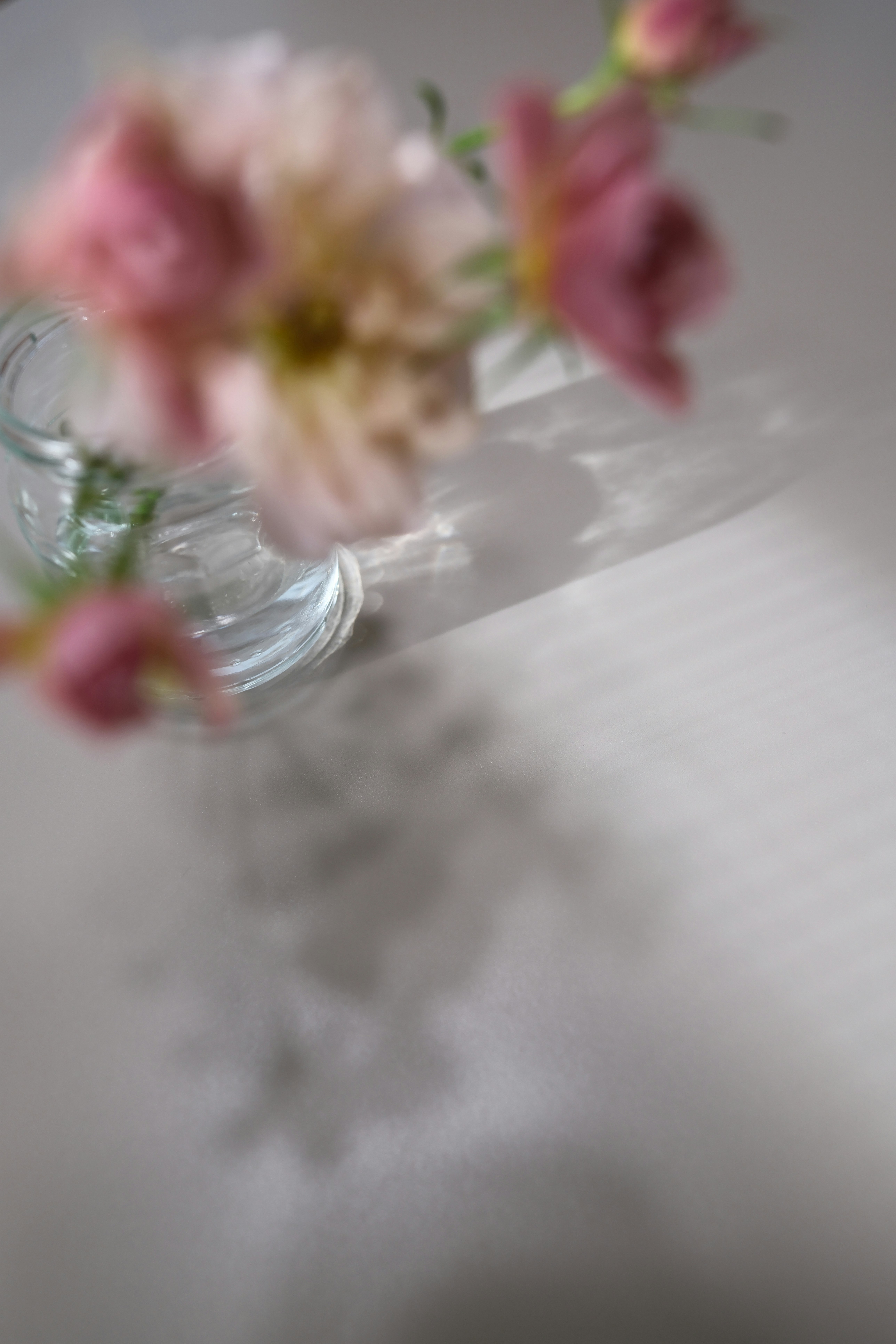 ぼけた花束と淡い布のあるテーブルの上