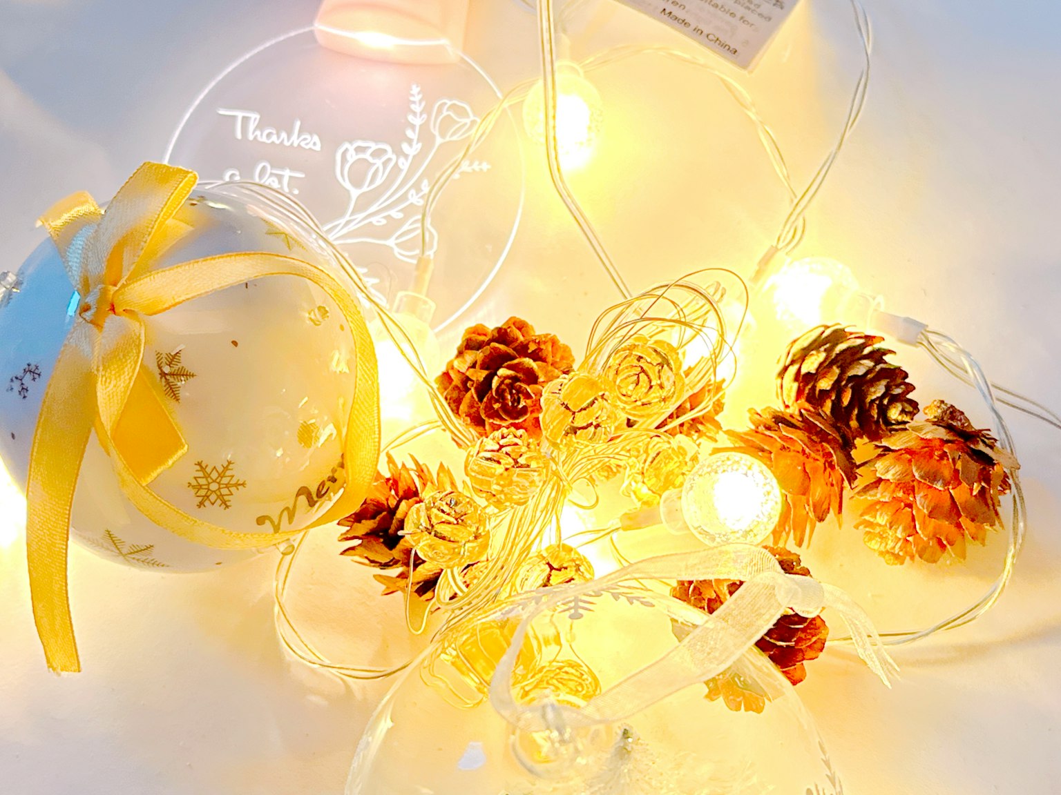 Adornos navideños y piñas rodeados de luces brillantes